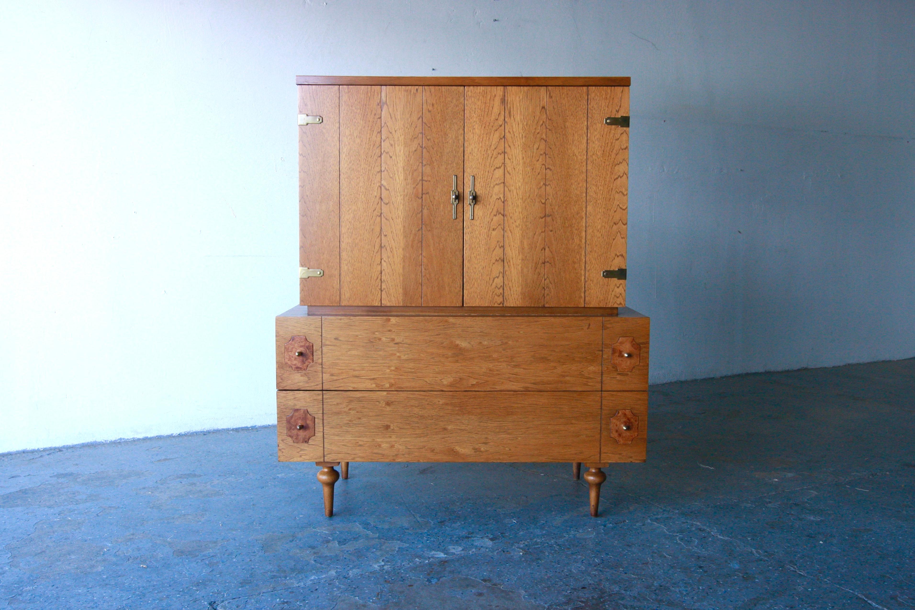 Mid Century modern highboy/gentlemen’s chest by American of Martinsville. Here is a beautiful mid-century highboy dresser which has loads of storage for all your goodies! The top portion has two open doors, which house 3 wood drawers. The bottom