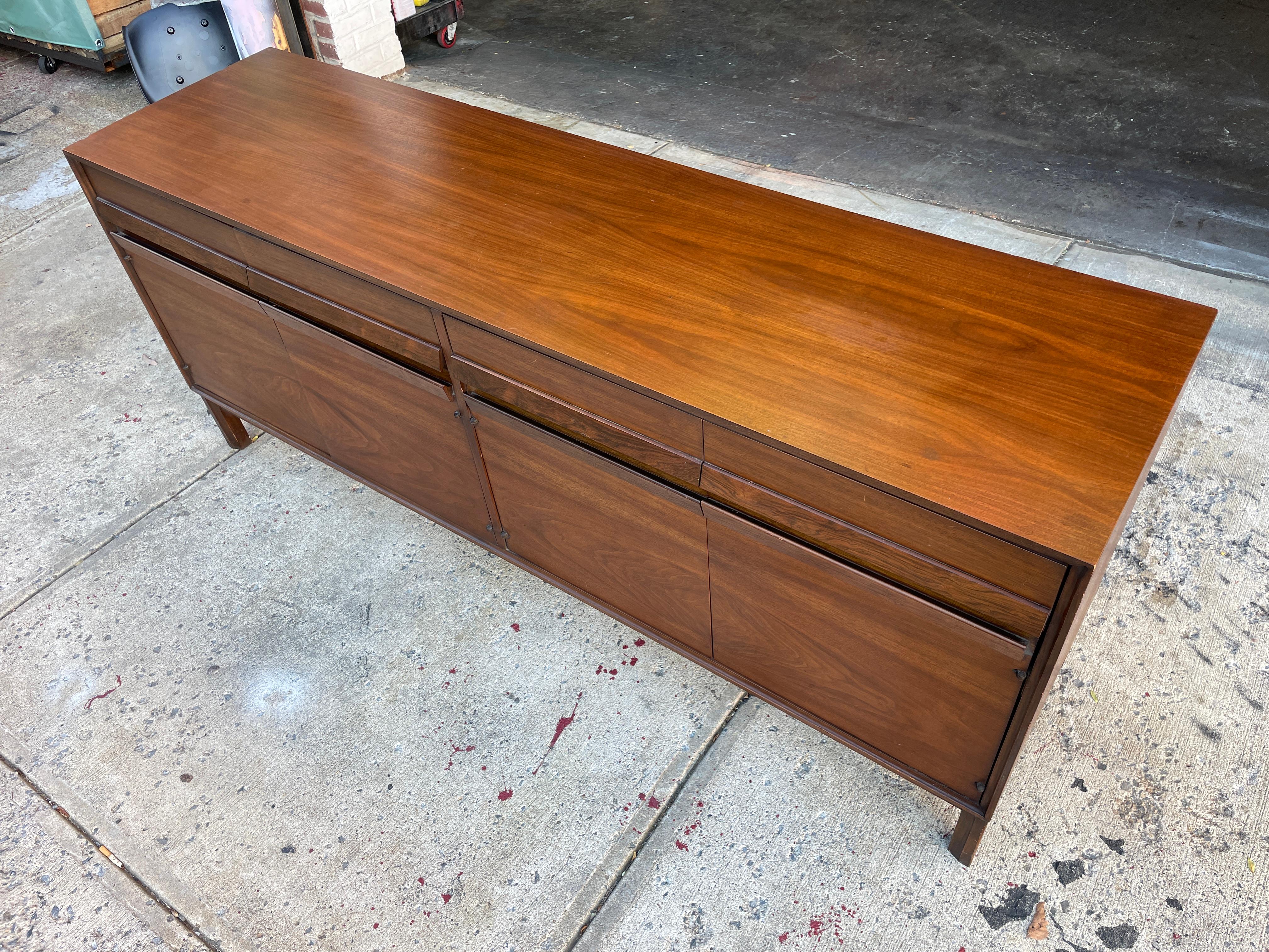 Mid-Century Modern American of Martinsville 4 drawer - 4 door credenza walnut. All Original Vintage condition - Dark brown walnut shows little wear - Solid wood handles. All drawers slide smooth and clean inside. Has a shelf on one side and a few