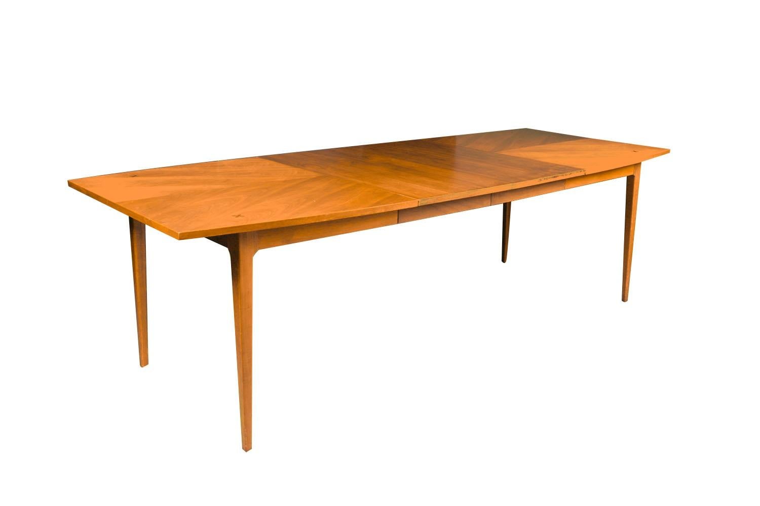 Stunning vintage Mid-Century Modern American of Martinsville walnut dining table in great original condition. Features a unique shaped sculpted top, accented with x-shaped rosewood star inlays adorning each of the four corners for a simple but