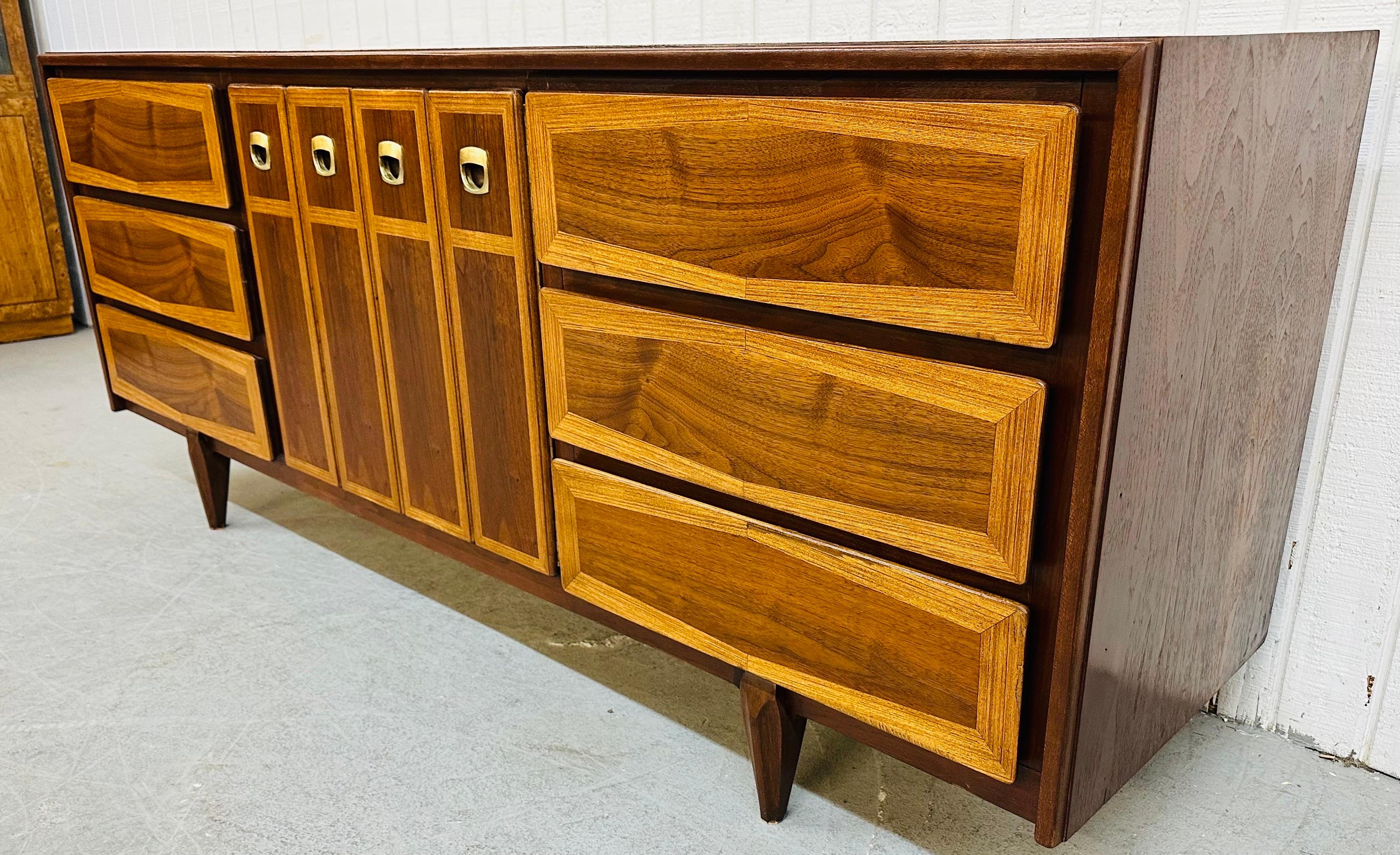 This listing is for a Mid-Century Modern American of Martinsville Walnut Dresser. Featuring six large drawers, center doors that open up to three hidden drawers, original hardware, and a beautiful two-tone walnut finish. This is an exceptional