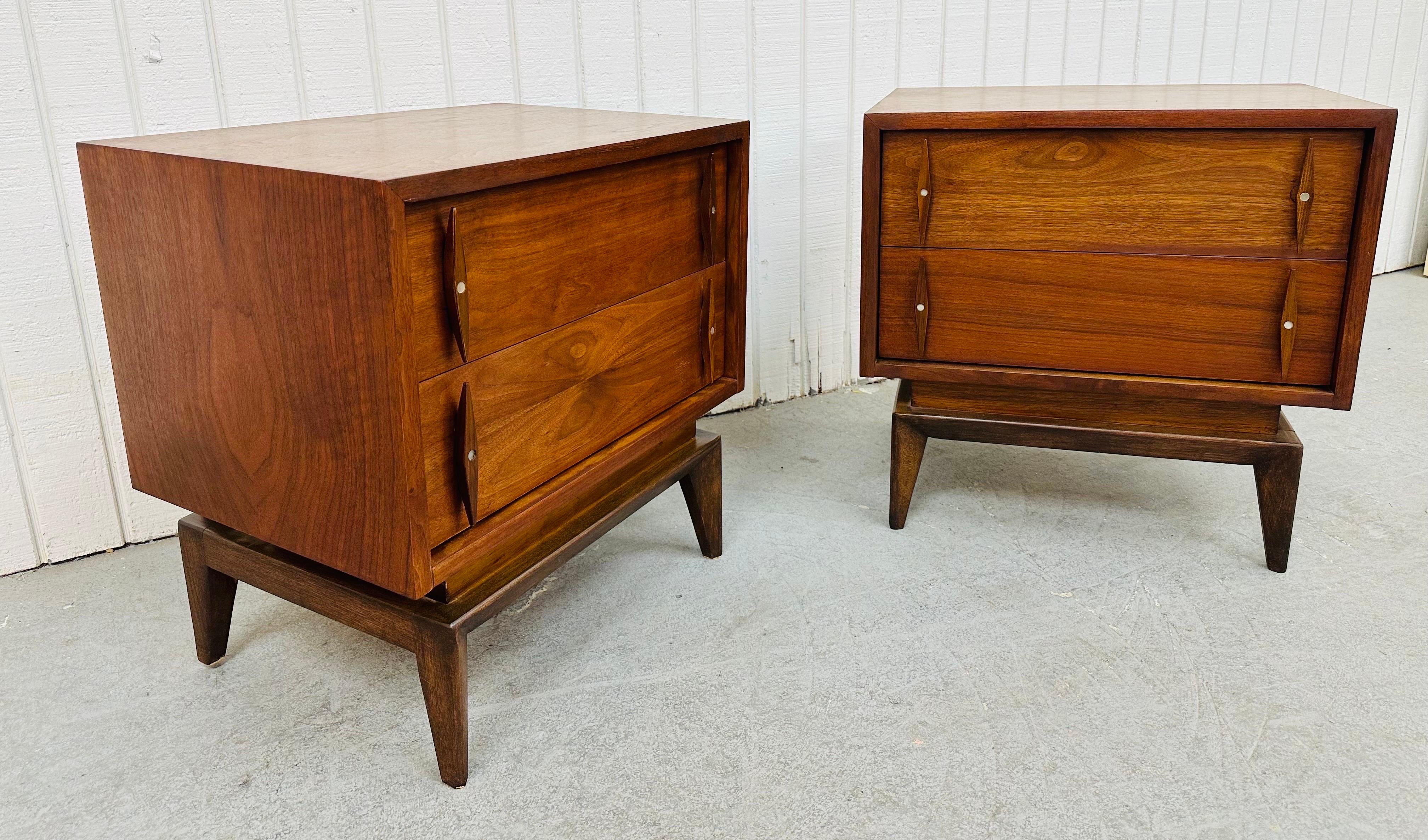 This listing is for a pair of Mid-Century Modern American Of Martinsville Walnut Nightstands. Featuring a straight line design, two drawers for storage, modern legs, Albert Pravin style sculpted pulls, and a beautiful walnut finish. This is an