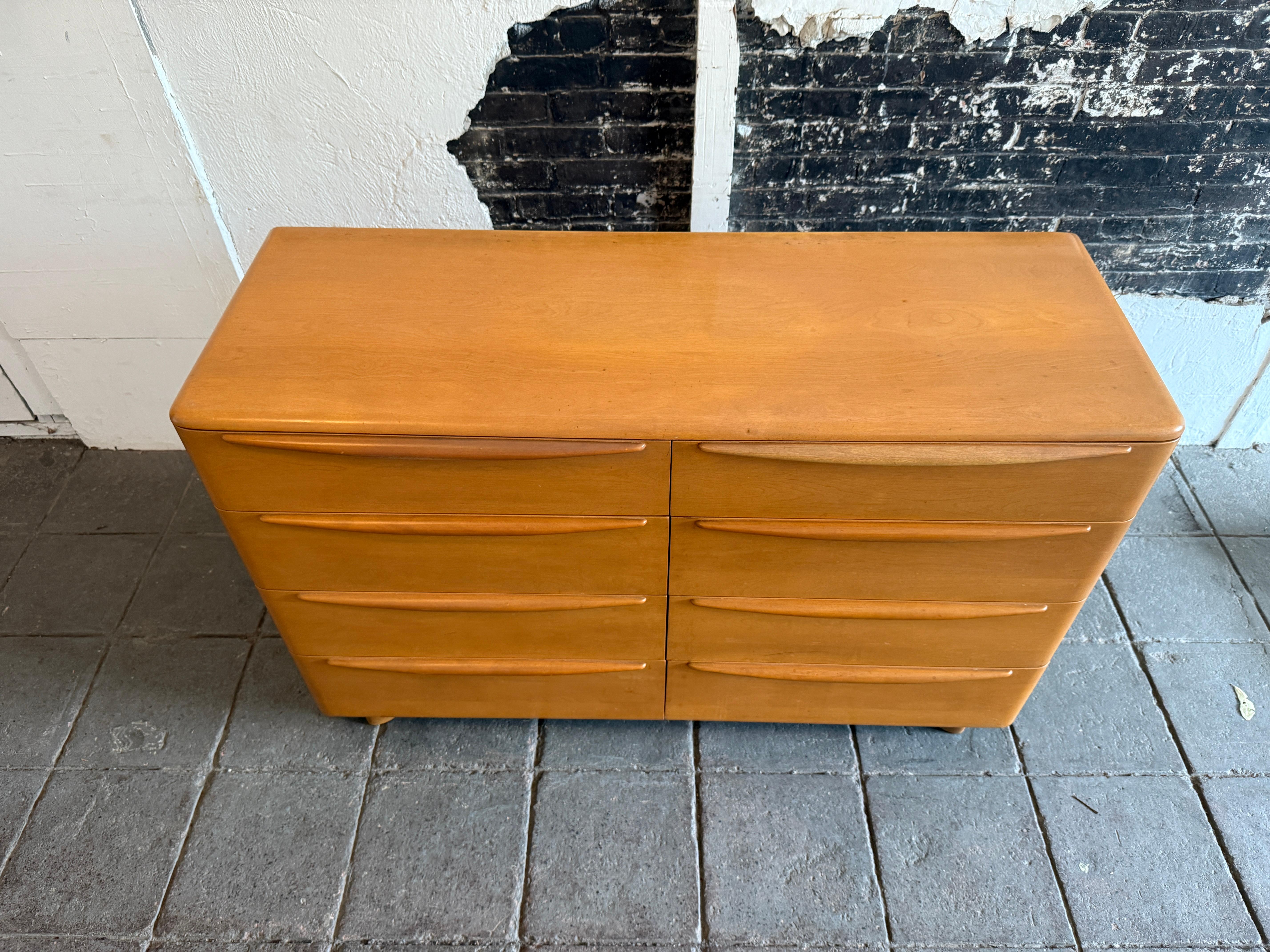 Timeless Heywood Wakefield Mid-Century Modern 8 drawer low dresser. All solid maple construction with sculpted legs and drawer handles. Good vintage condition original blonde champagne finish clean inside and out. Shows normal wear and use. Label