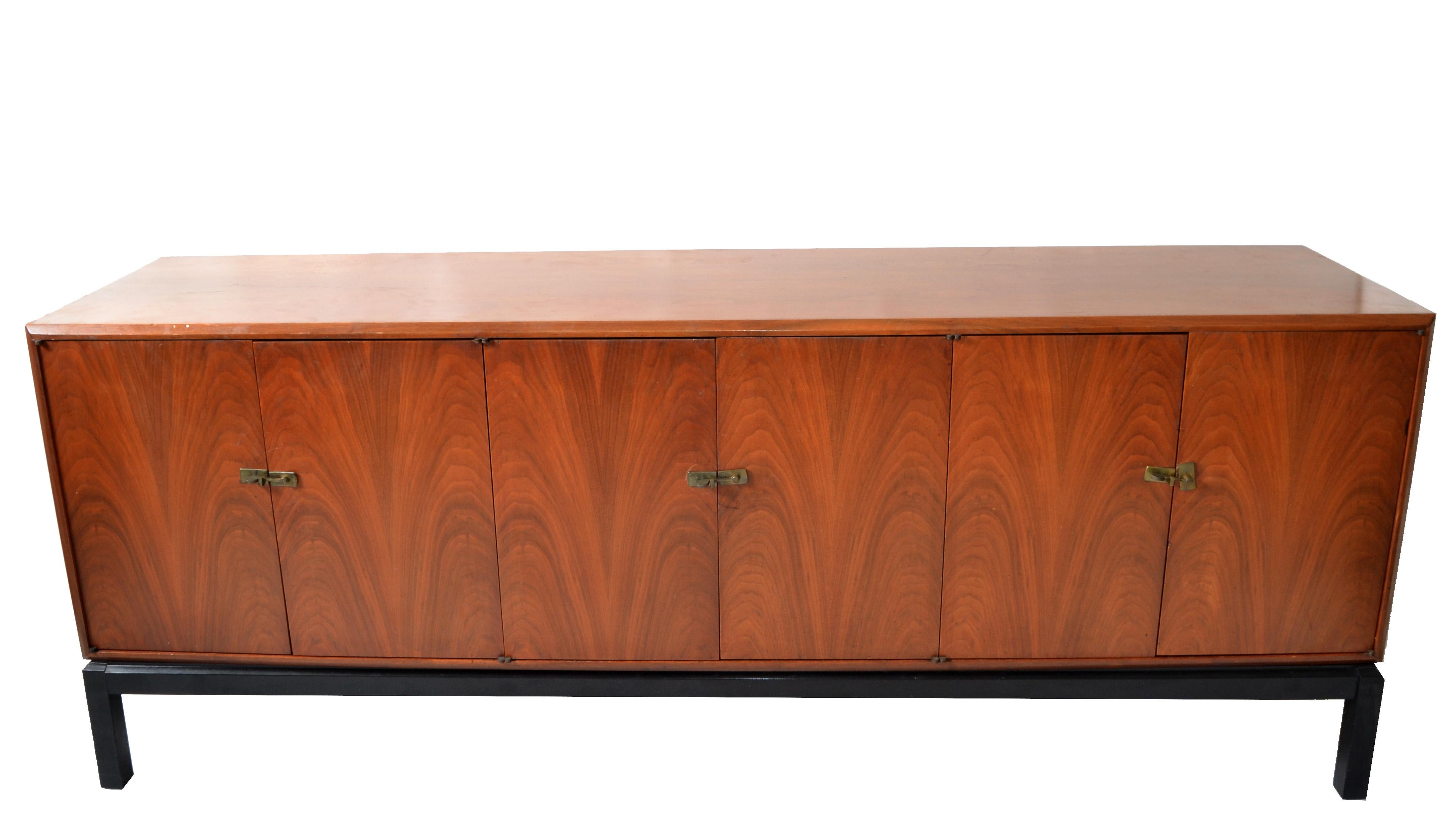 Large Mid-Century Modern American Credenza in Walnut with Brass Hardware made in the 1960.
Features one door on the left with one shelf, the middle with 3 drawers, and the right side with 2 shelves.
The Base Frame with the four legs attached is