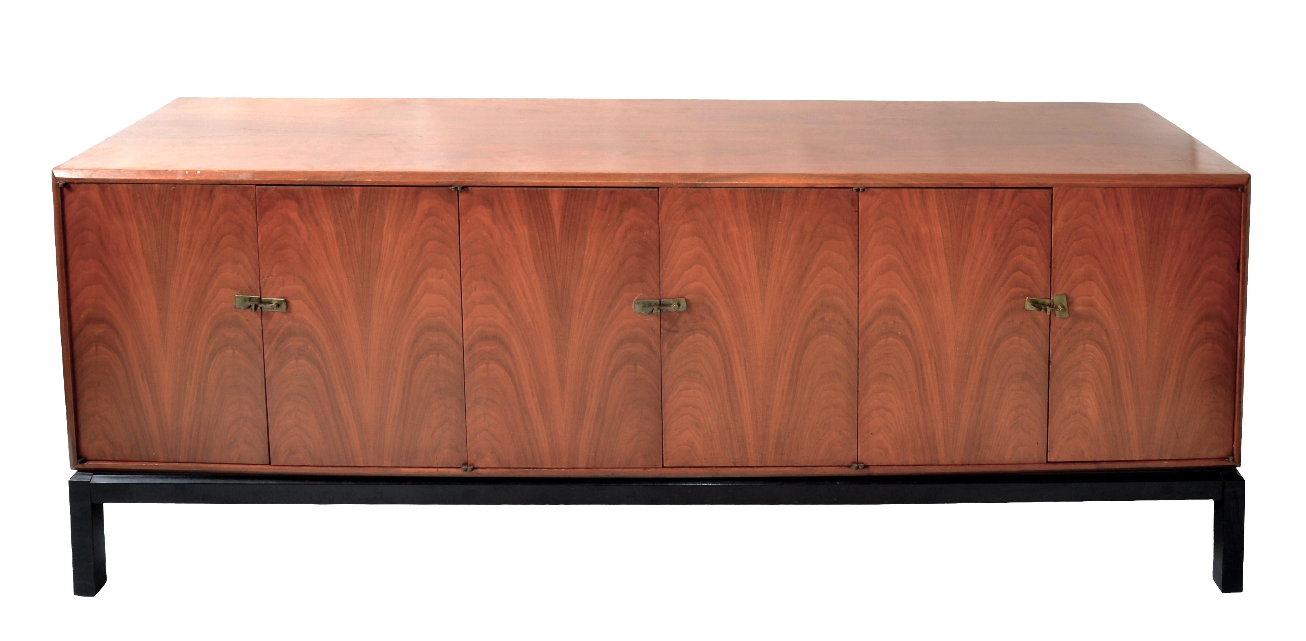 Grande credenza americana in stile Harvey Probber del Mid-Century Modern in noce con ferramenta in ottone realizzata nel 1960.
Presenta un'anta a sinistra con un ripiano, il centro con 3 cassetti e il lato destro con 2 ripiani.
Il telaio della base