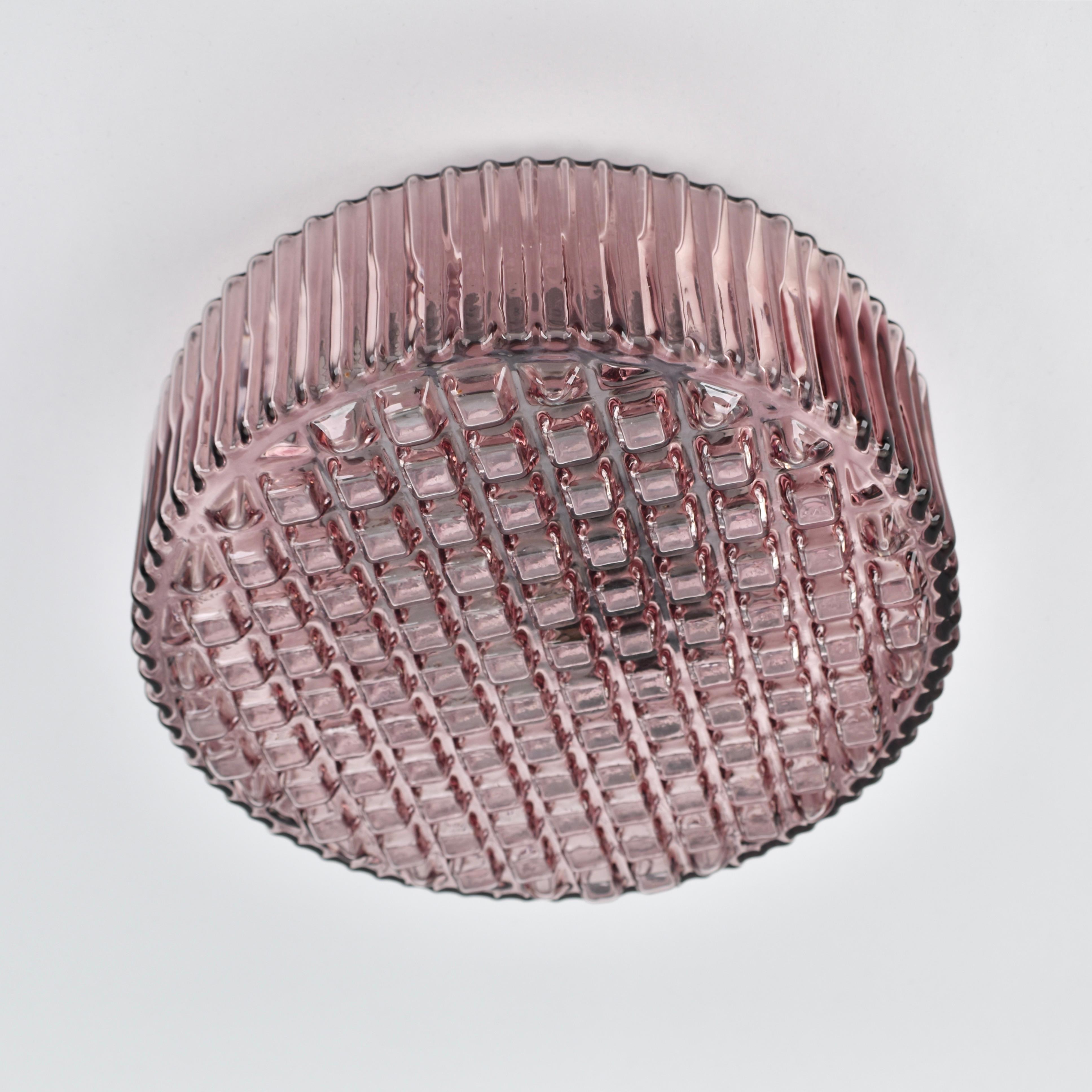 Rara montura empotrada con una pantalla de cristal de color púrpura amatista. Esta lámpara tiene un diseño atrevido que recuerda a los diseños de Helena Tynell. La base está hundida en la pantalla, de modo que la lámpara se apoya cómodamente en el