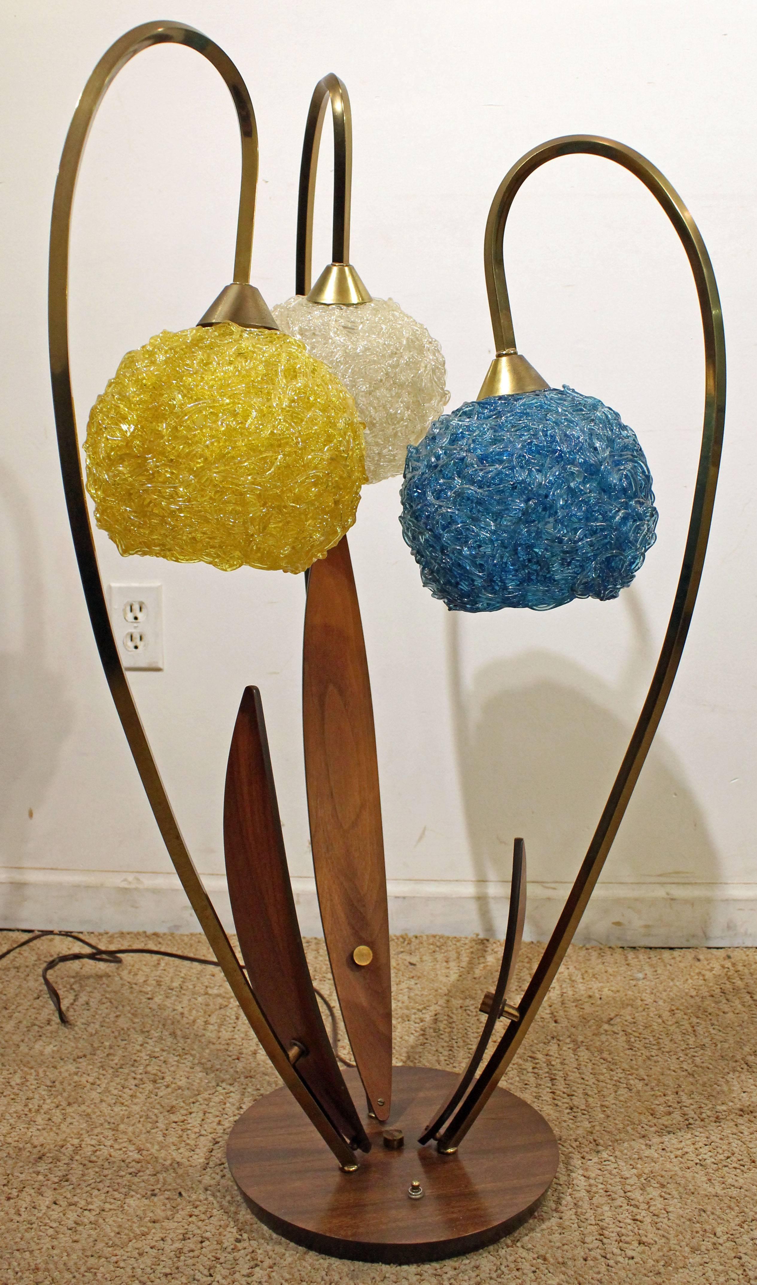 This piece is a three-way table lamp, made with walnut, brass, and spun fiberglass shades. Lamp has been tested and is in good working condition.