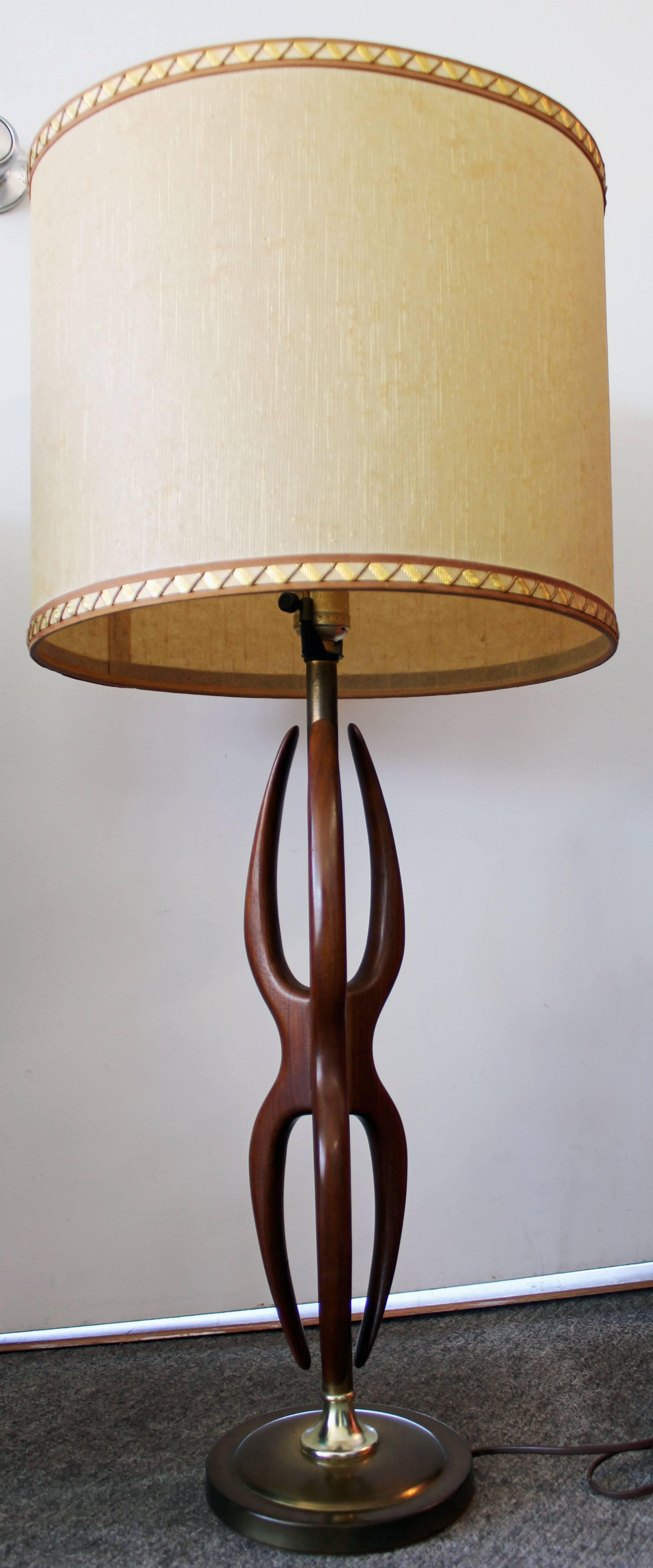 Offered is a Mid-Century Modern amorphous-shaped table lamp, made of walnut and brass. It is in excellent working condition. Shade is not included, for display purposes only.