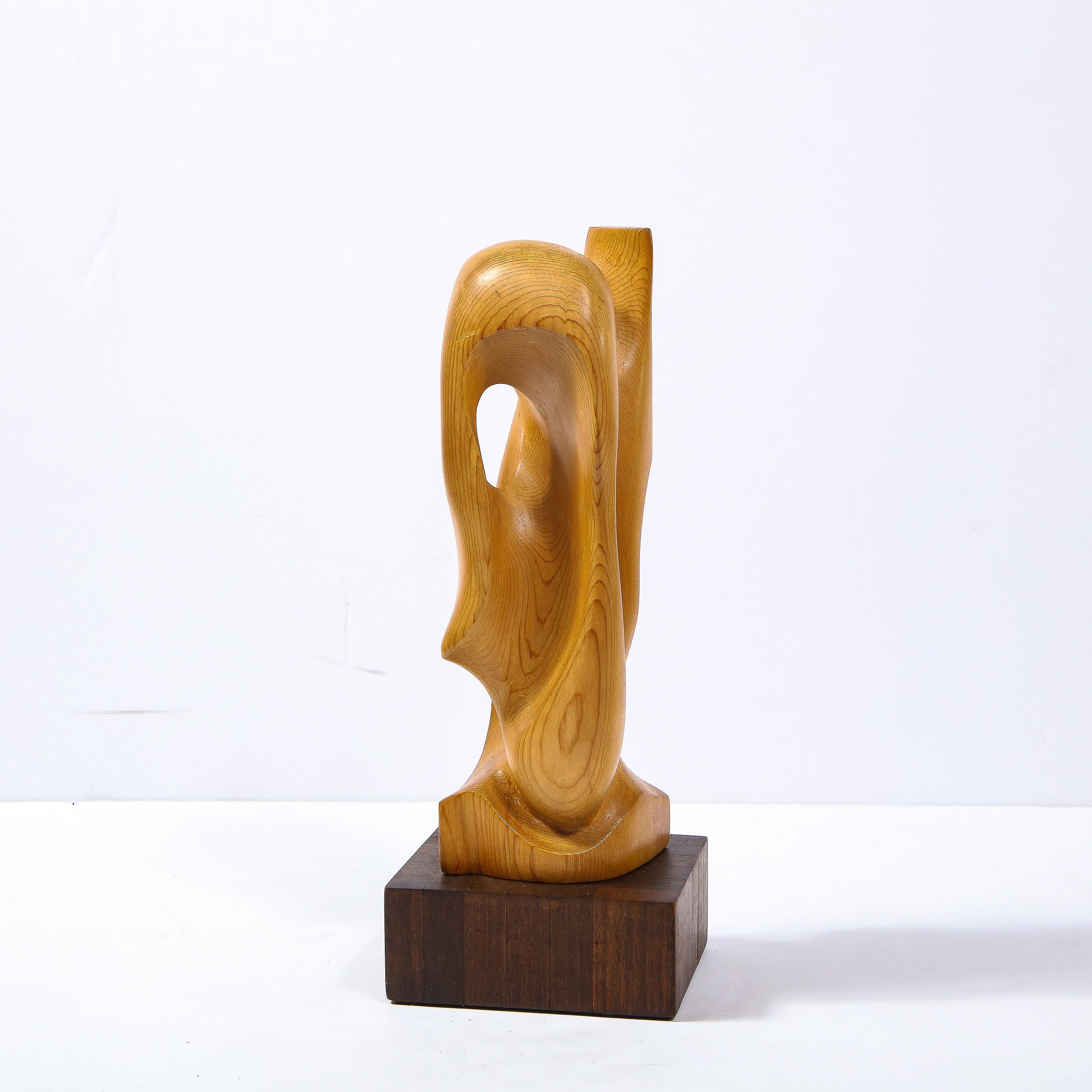 This elegant and sophisticated Mid Century Modern sculpture was realized in the United States circa 1960. It features a curvilinear amorphic abstract body consisting of a panoply of interlacing forms. Composed of hand rubbed oak- showcasing the