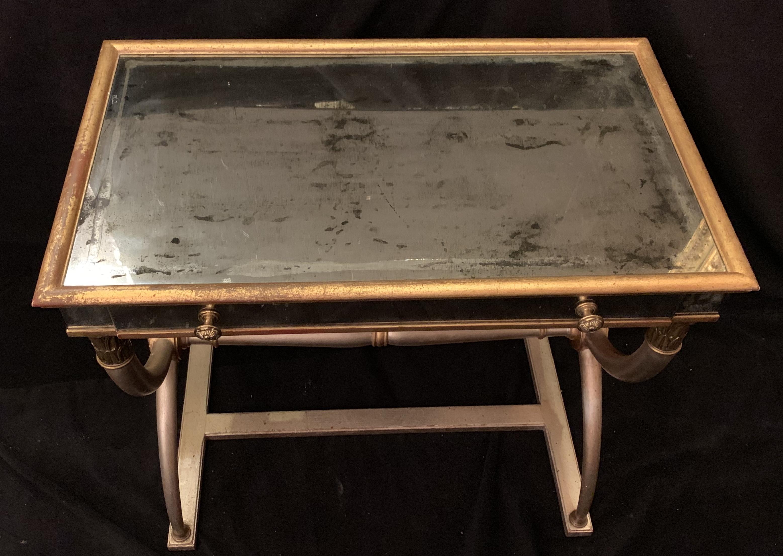 A wonderful Mid-Century Modern pair of antique mirrored, silver and gold gilt night / end tables in the manner of Baguès with a single pull out drawer each.