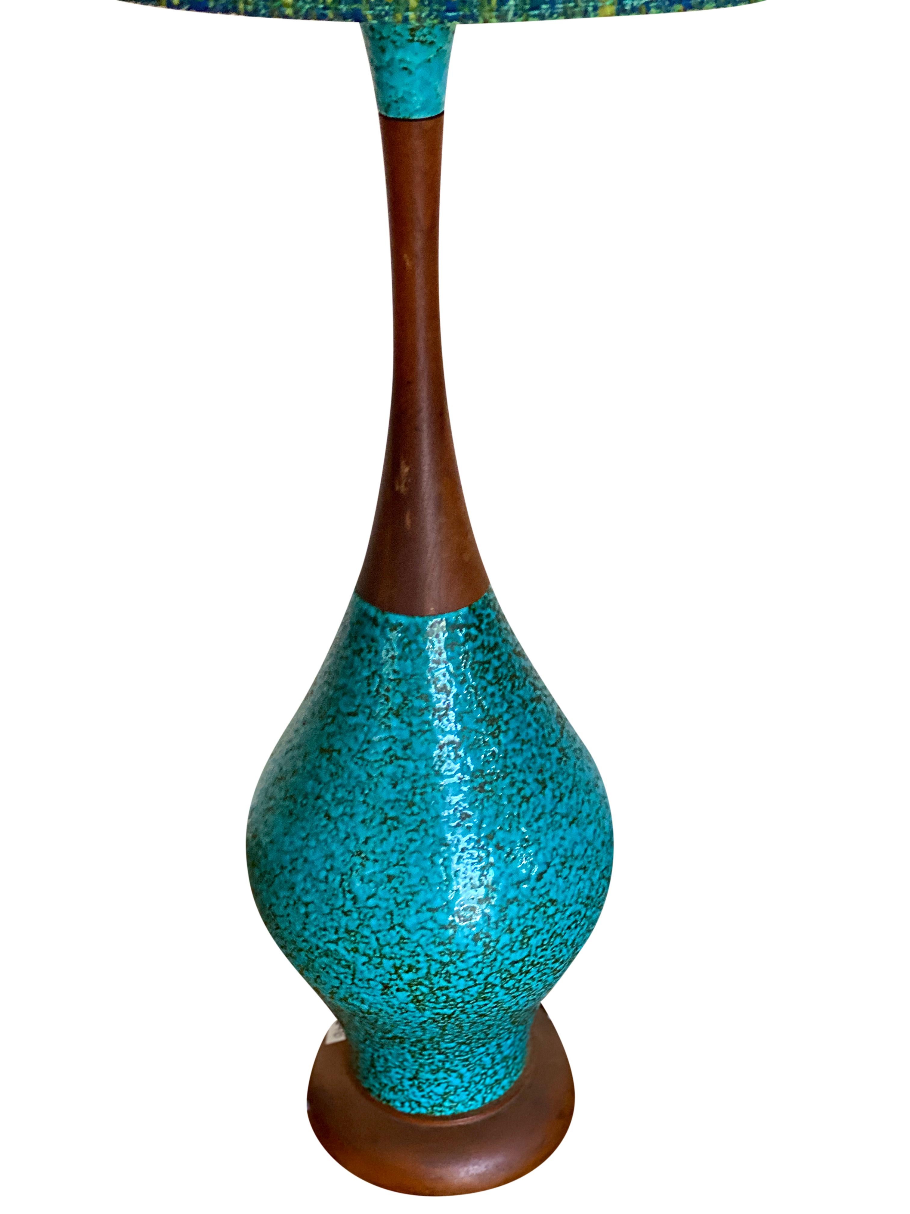 Beautiful aqua-colored ceramic and wood Mid-Century Modern lamp. This lamp has a tall elegant shape that is a great accent piece to any vignette. The lampshade is original to the lamp and is in good condition.