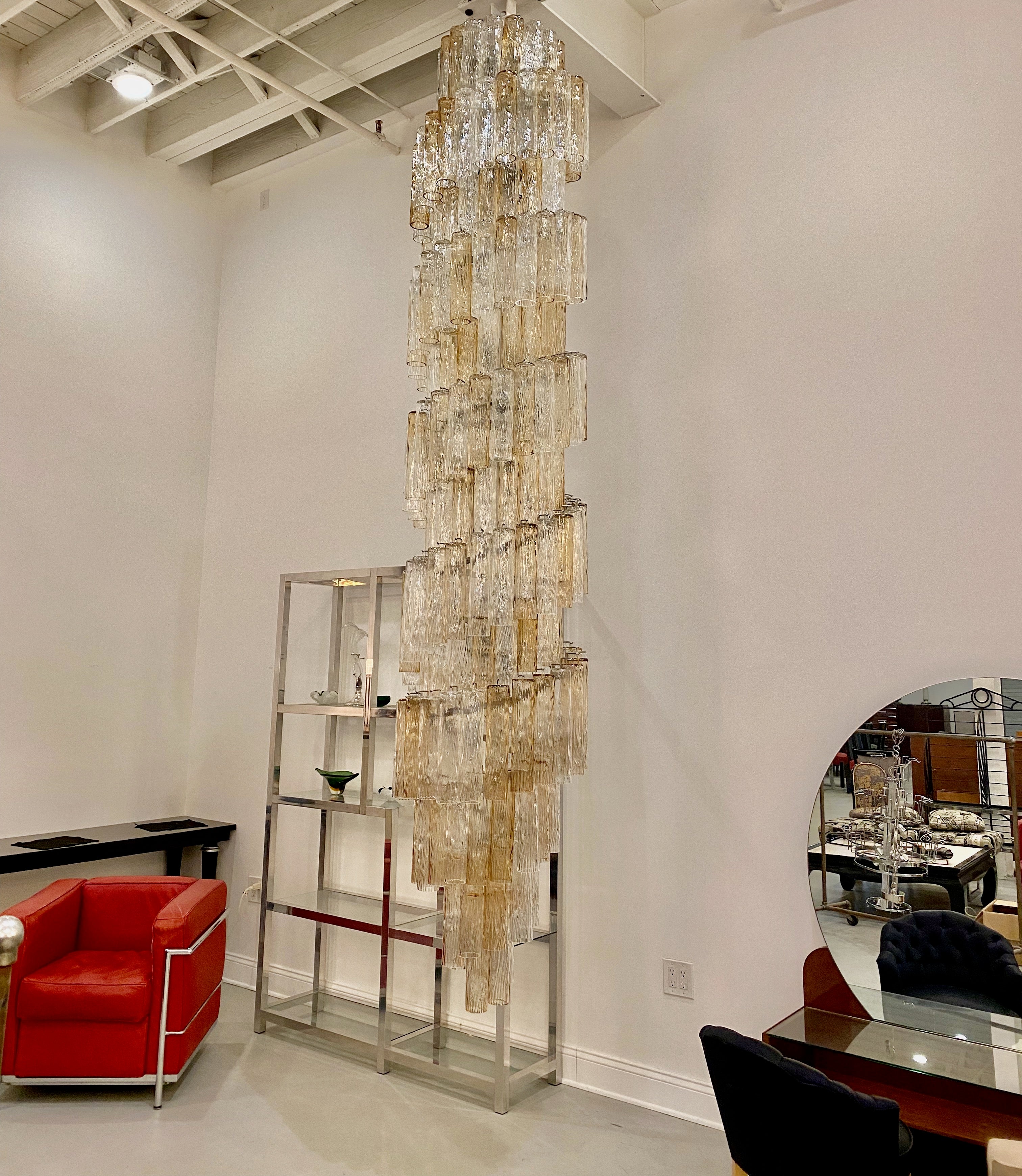 Stunning Mid Century Modern Italian Chandelier by talented artist Archimede Seguso. This double waterfall chandelier has Tronchi glass tubes hanging from hooks onto a nickel (silver) frame, as pictured. The is one of the tallest chandeliers hanging