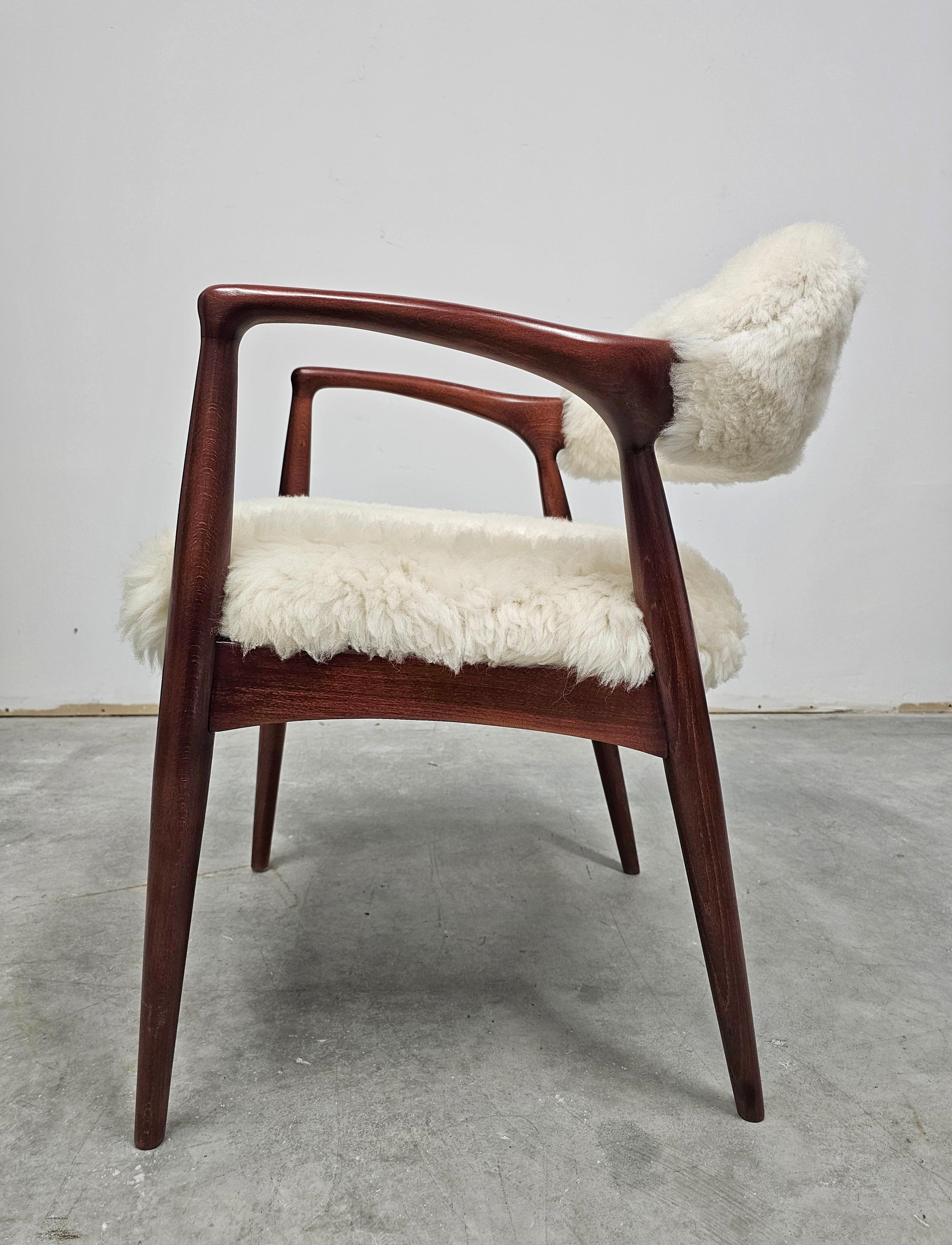 In this listing you will find a refined and stylish Mid Century Modern armchair done in beech and upholstered in lambkin, combining perfectly the off-white color of the lamb fur and chestnut stain of the wood. It gives warm, fluffy and yet very