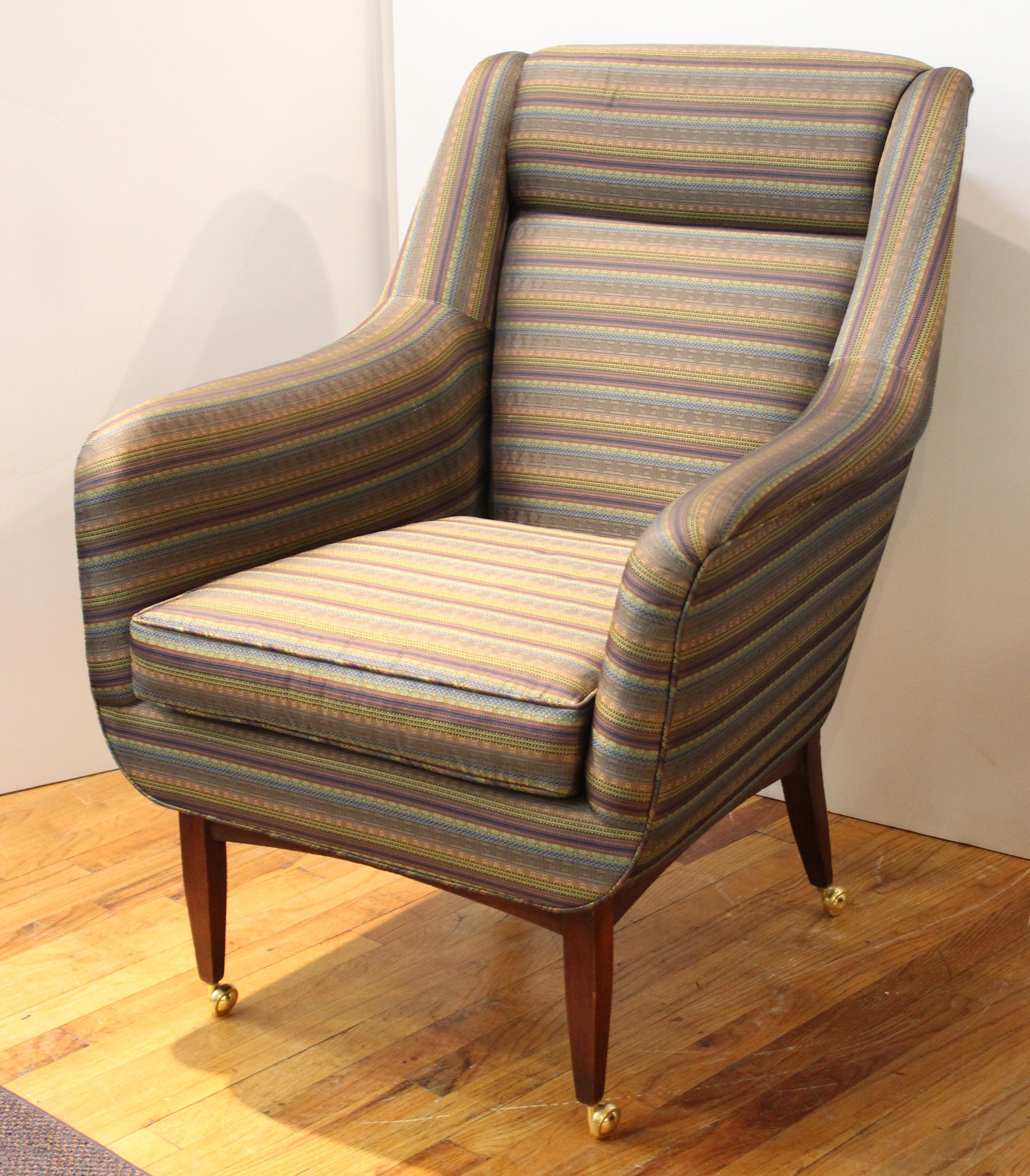 Mid-Century Modern lounge chair or armchair with matching foot stool on casters with decorative geometric pattern upholstery. The pair is in great vintage condition with age-appropriate wear.
