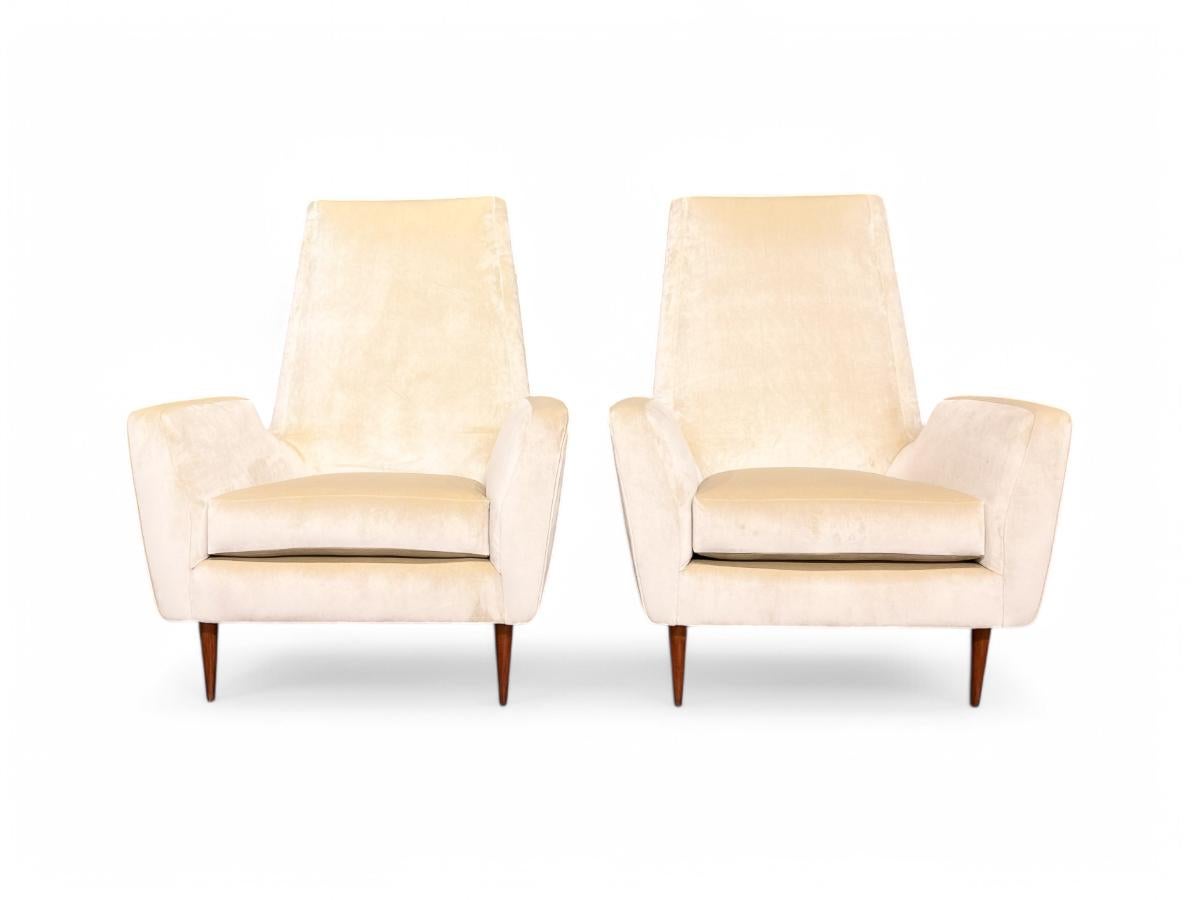 This pair of two high back armchairs has the typical Scapinelli style with its delicate lines and soft sensual shapes. The chairs rest on straight tapered legs supporting the sophisticated Beige Velvet cushions. The chairs are both comfortable with