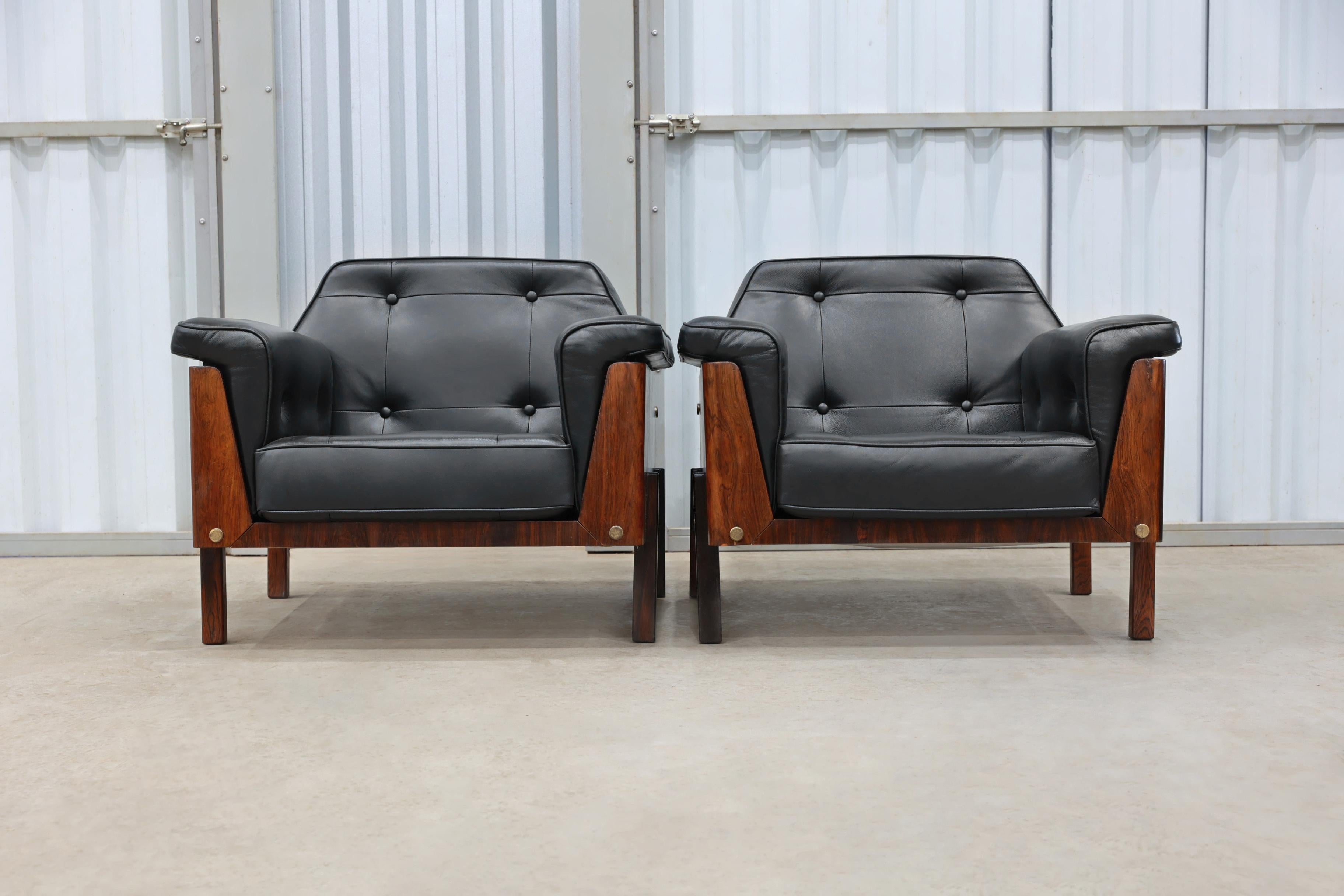These unique looking armchairs feature a square base made in Brazilian rosewood (Jacaranda). They have been upholstered in black leather and the back seat has been tufted with four buttons. The structure of the backseat has an incredible design