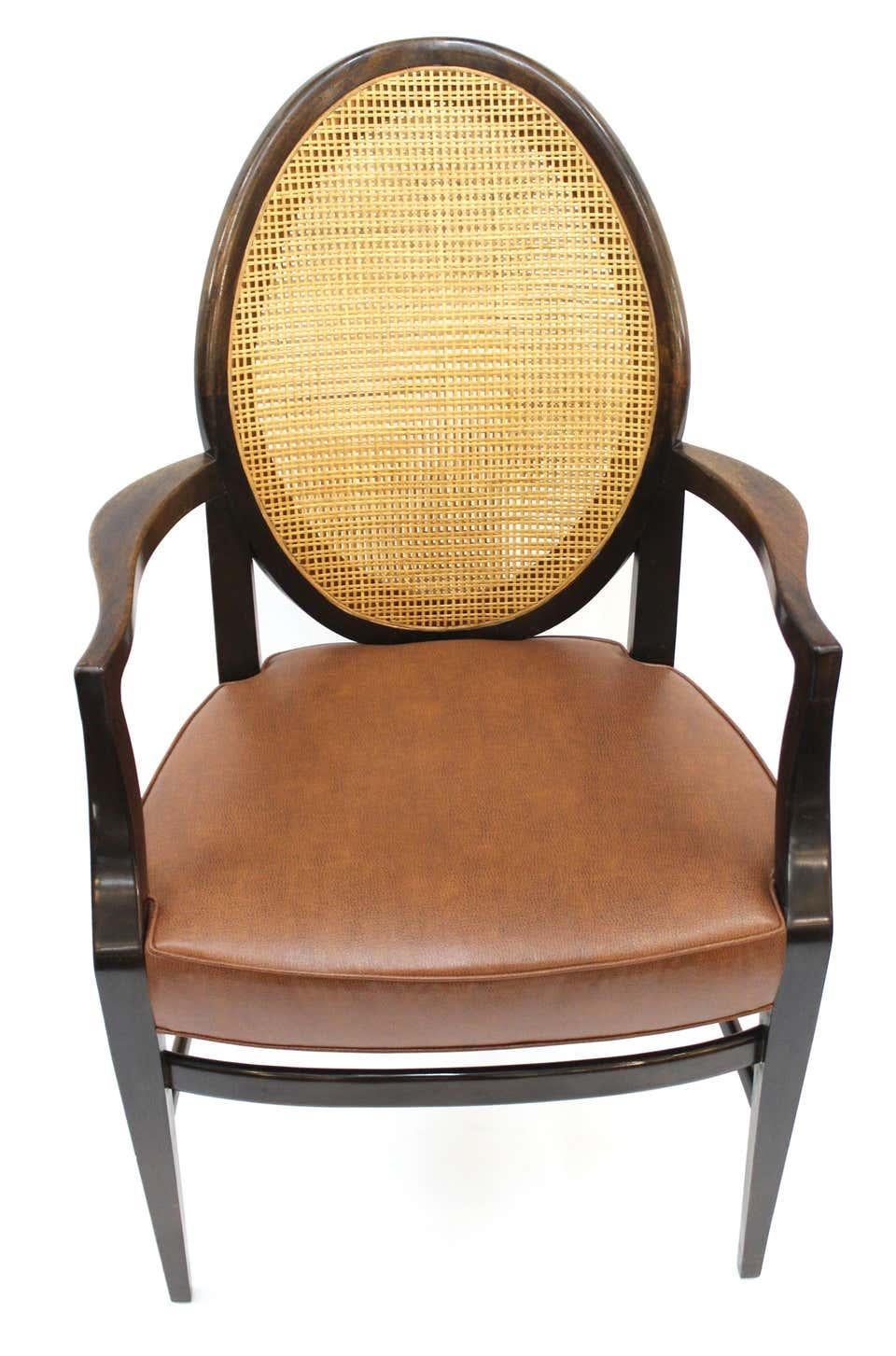 American Mid-Century Modern pair of armchairs with caned backs and faux-leather upholstered seats, attributed to Harvey Probber during the 1960s. The pair is in great vintage condition and has been completely restored.