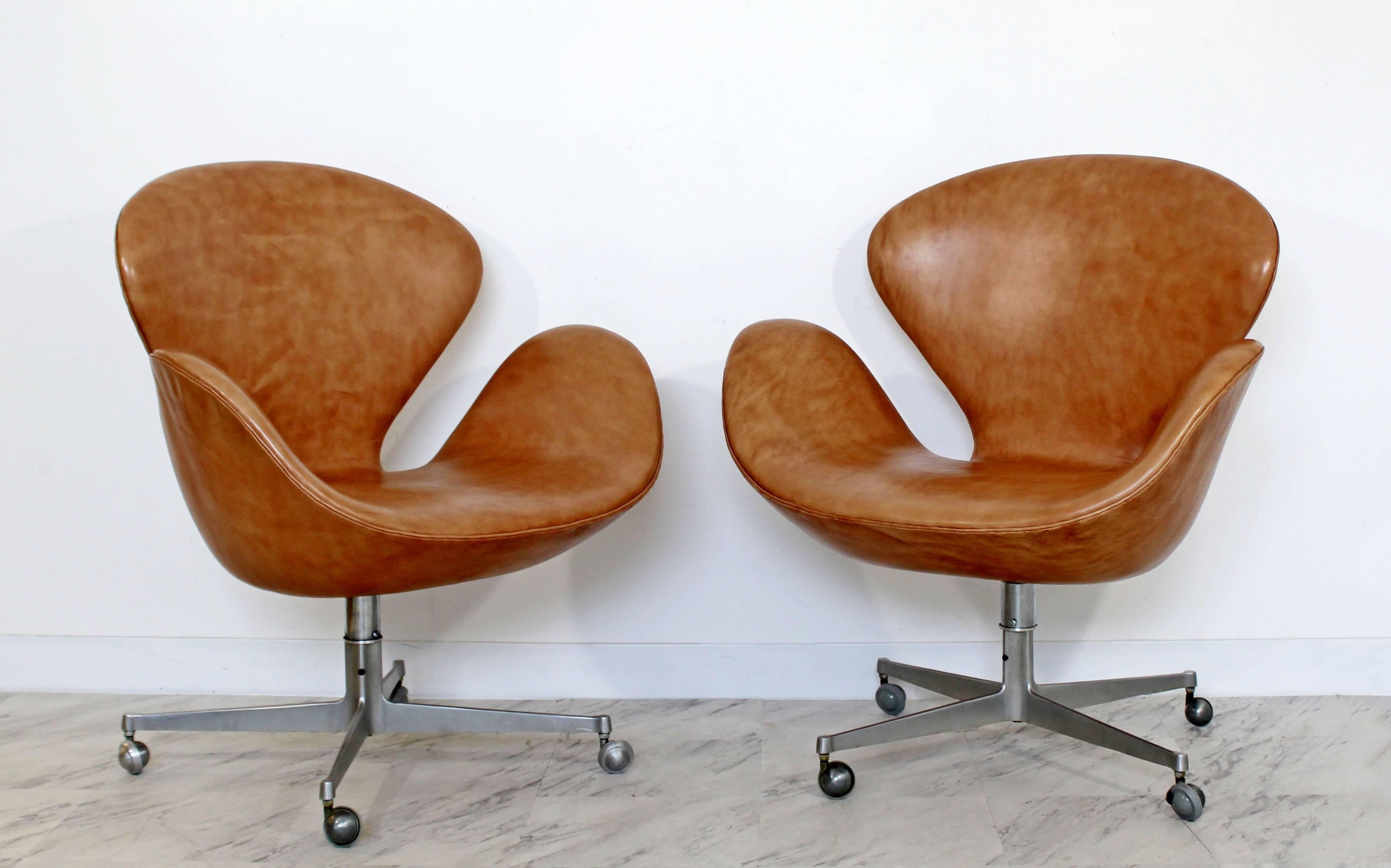 For your consideration is a magnificent pair of swivel, swan chairs on casters, by Arne Jacobsen for Fritz Hansen, circa 1960s in Denmark. In a gorgeous leather upholstery. In excellent condition. The dimensions are 30