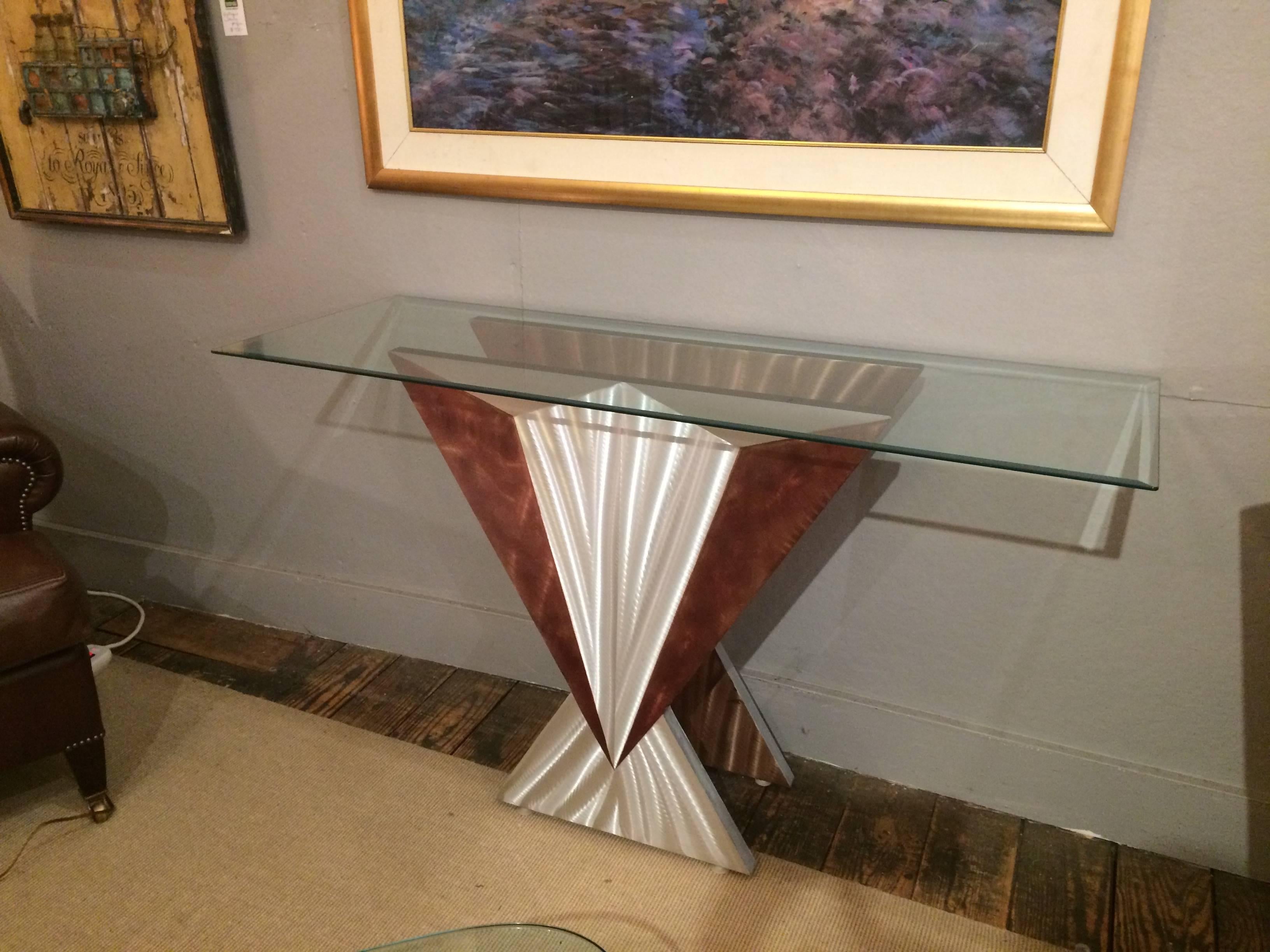 A sleek sophisticated take on Art Deco styling with angular silver and brown brushed steel base having a triangular motife. Heavy bevelled narrow rectangular glass top.