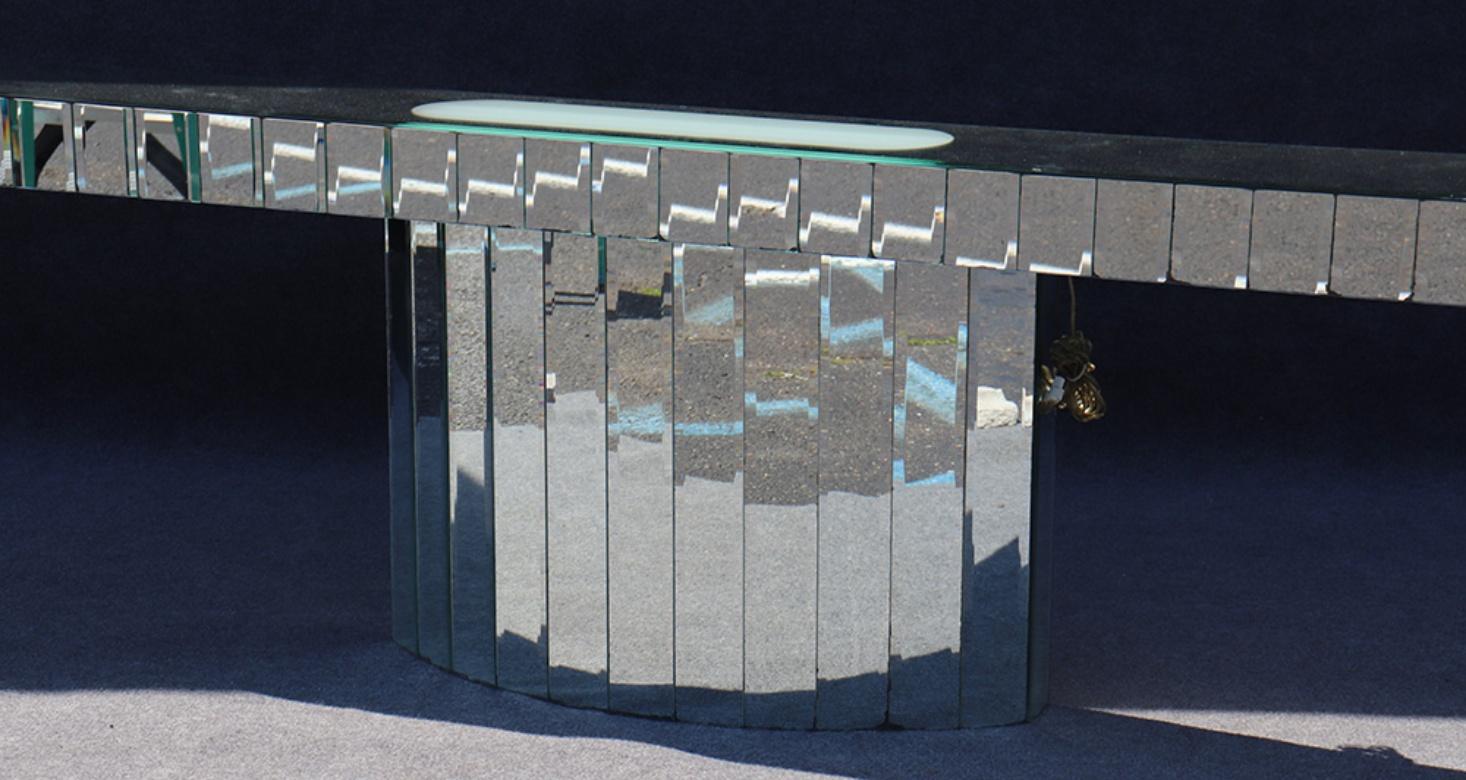 This console table was custom made for a huge wall. This was made with many beveled glass mirrored panels. The glass is in good original condition with some age-related silver loss behind the glass on a few panels but this is entirely normal for