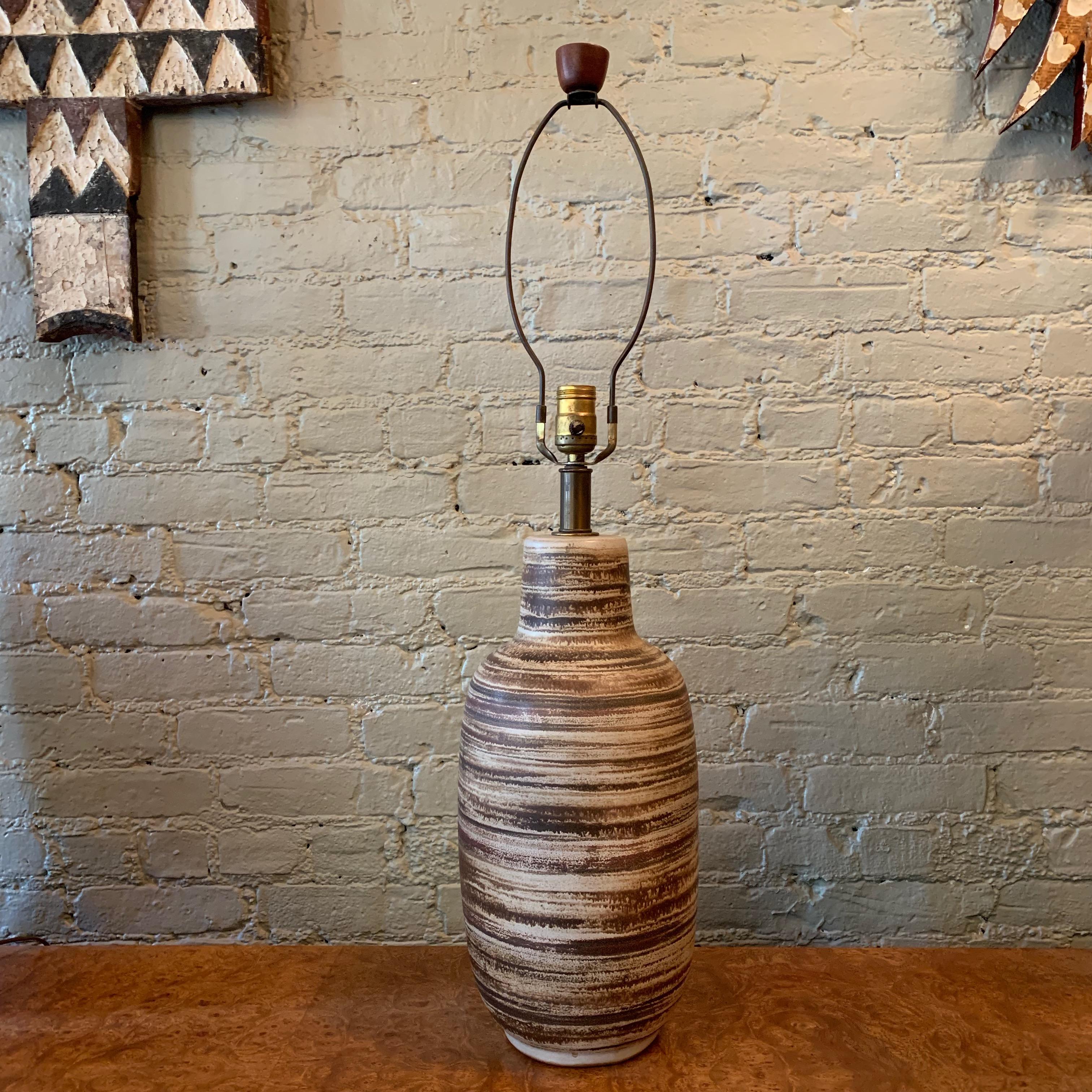 Tall, Mid-Century Modern, art pottery, table lamp by Gordon Martz for Marshall Studios features a swirled, earthen tone, ceramic gourd base with brass hardware and walnut finial. Height to the socket is 22 inches and over height is 32 inches.