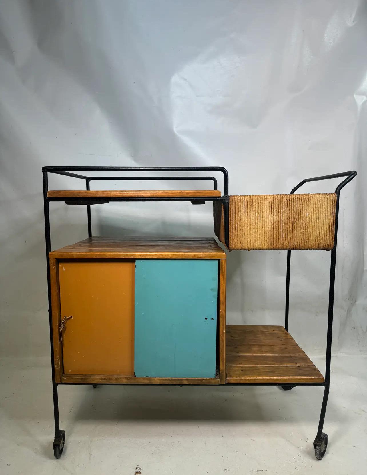 This stunning Arthur Umanoff bar cart combines wrought iron and wood, showcasing a fantastic 1960s aesthetic. It features a beautiful blend of wood, metal, and rush materials, making it a perfect addition to any space.