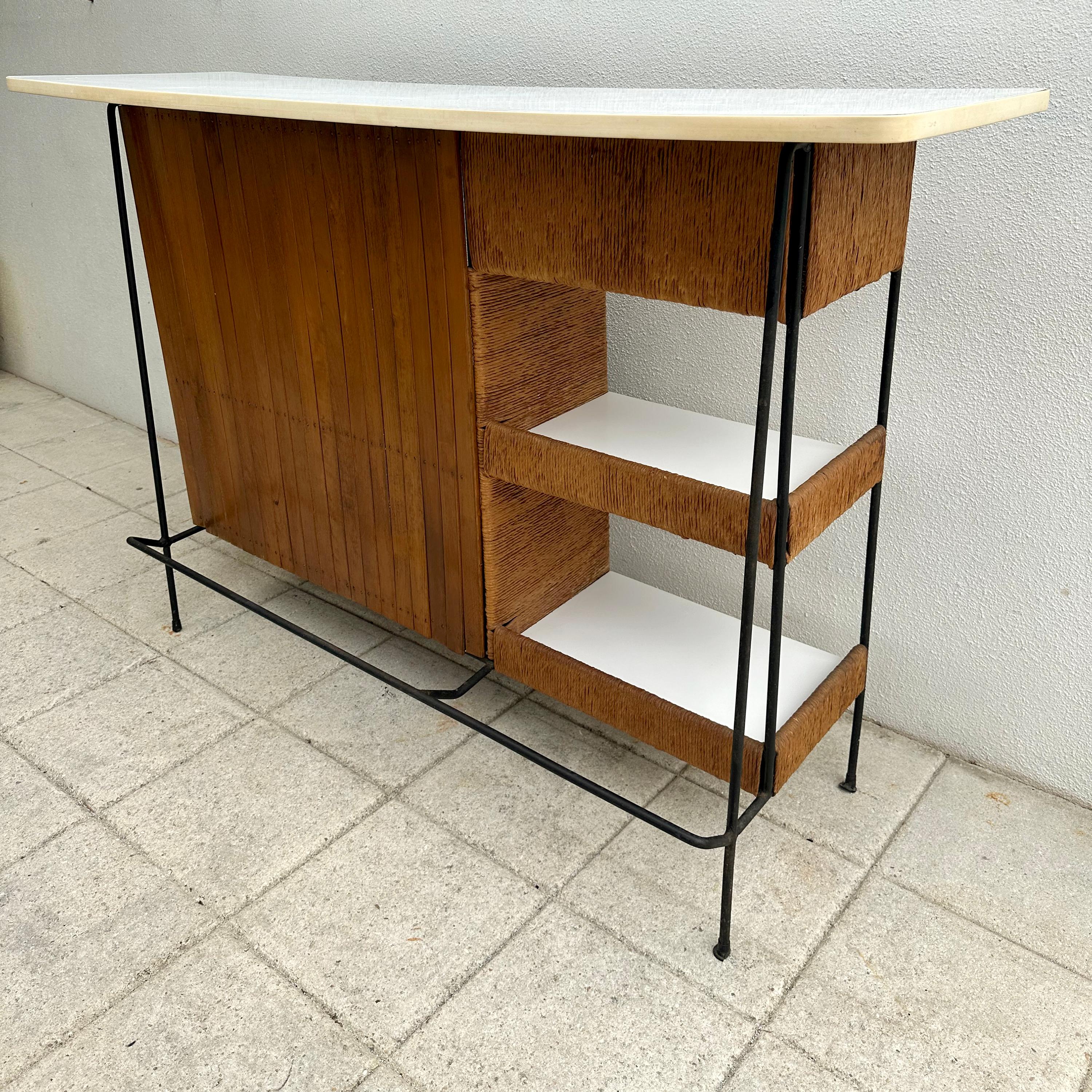 Vintage 1950s-60s wood slat, rope and wrought iron bar. Features white laminate top with multiple shelves in the back and side. Vintage condition, slight curvature to the top, shows some wear throughout and white rubber edging is missing a few bits