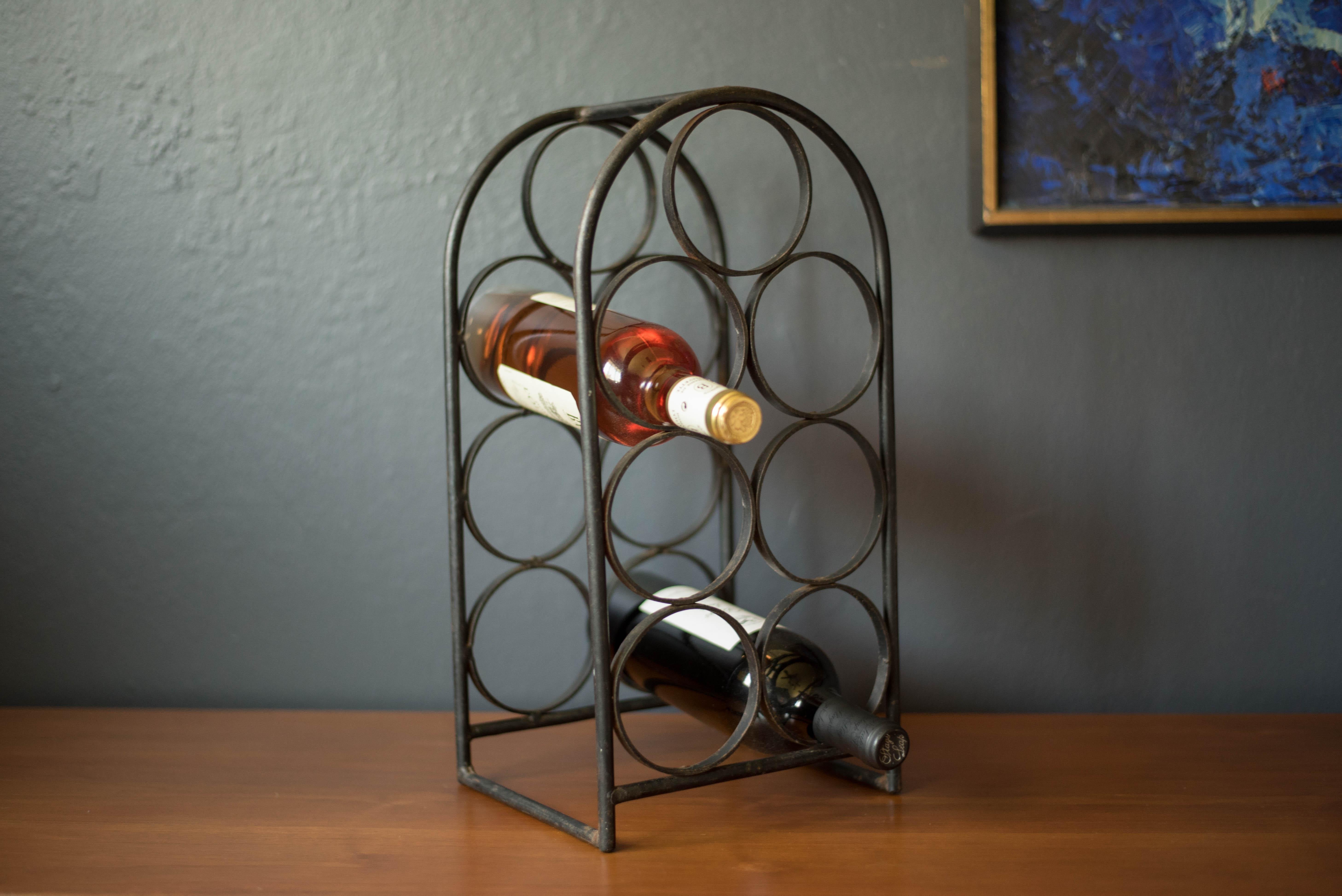 Vintage wrought iron wine rack designed by Arthur Umanoff for Shaver Howard. This piece accommodates up to seven bottles and offers additional storage display for the kitchen countertop or bar table.