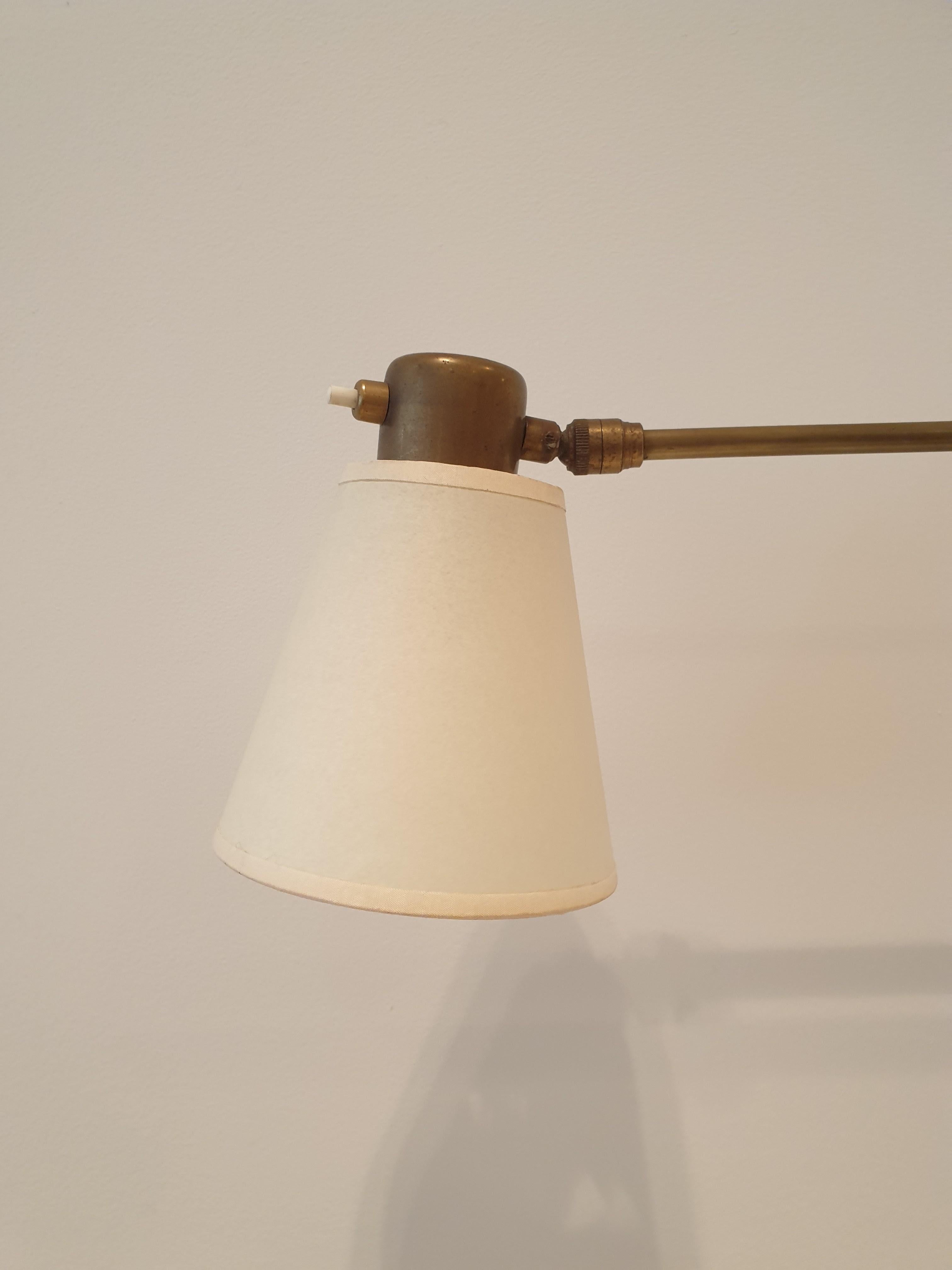 Useful patinated brass articulated wallight with bespoke parchment shade. The shade tilts and the arm can be folded back against the wall if required. It makes an excellent reading light or light over the bed as it can be folded against the wall. It