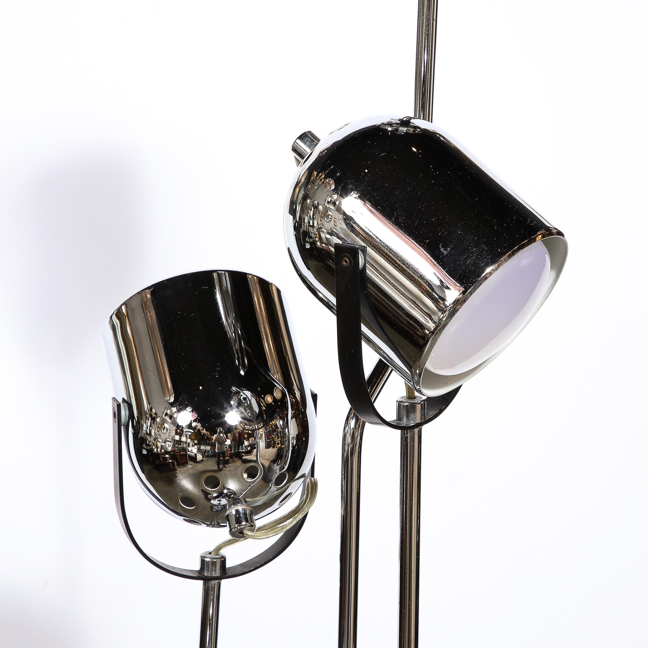 This refined Mid-Century Modern chrome and black enamel floor lamp was realized in the United States circa 1970. Four serpentine zig zagging cylindrical chrome supports ascend from a volumetric rectangular base culminating in cupped concave shades-