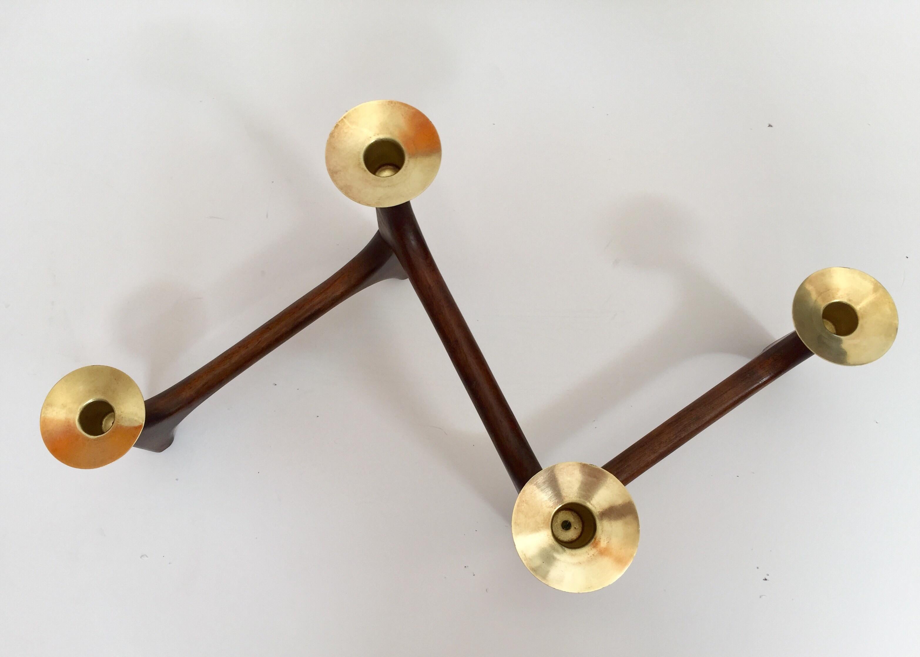Vintage 1960s modernist candle holder, teak and polished brass articulating candlestick.
Mid-Century Modern handcrafted modern teak wood and brass candlestick centerpiece.
This stained wooden candle holder features a folding frame with four brass