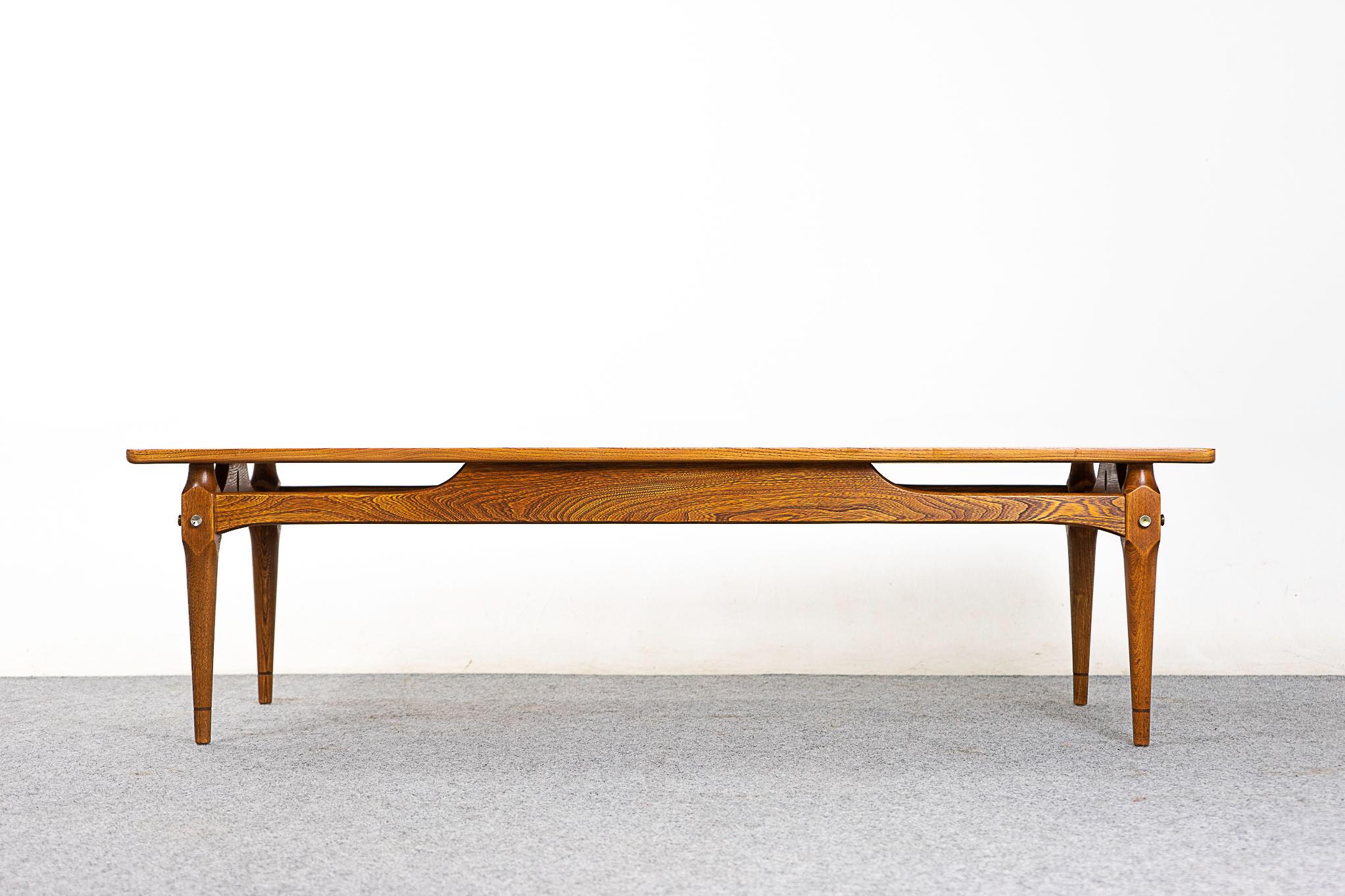 Ash wood midcentury coffee table, circa 1960s. Floating top shows beautiful book matched veneer, solid wood curved edge along its length.