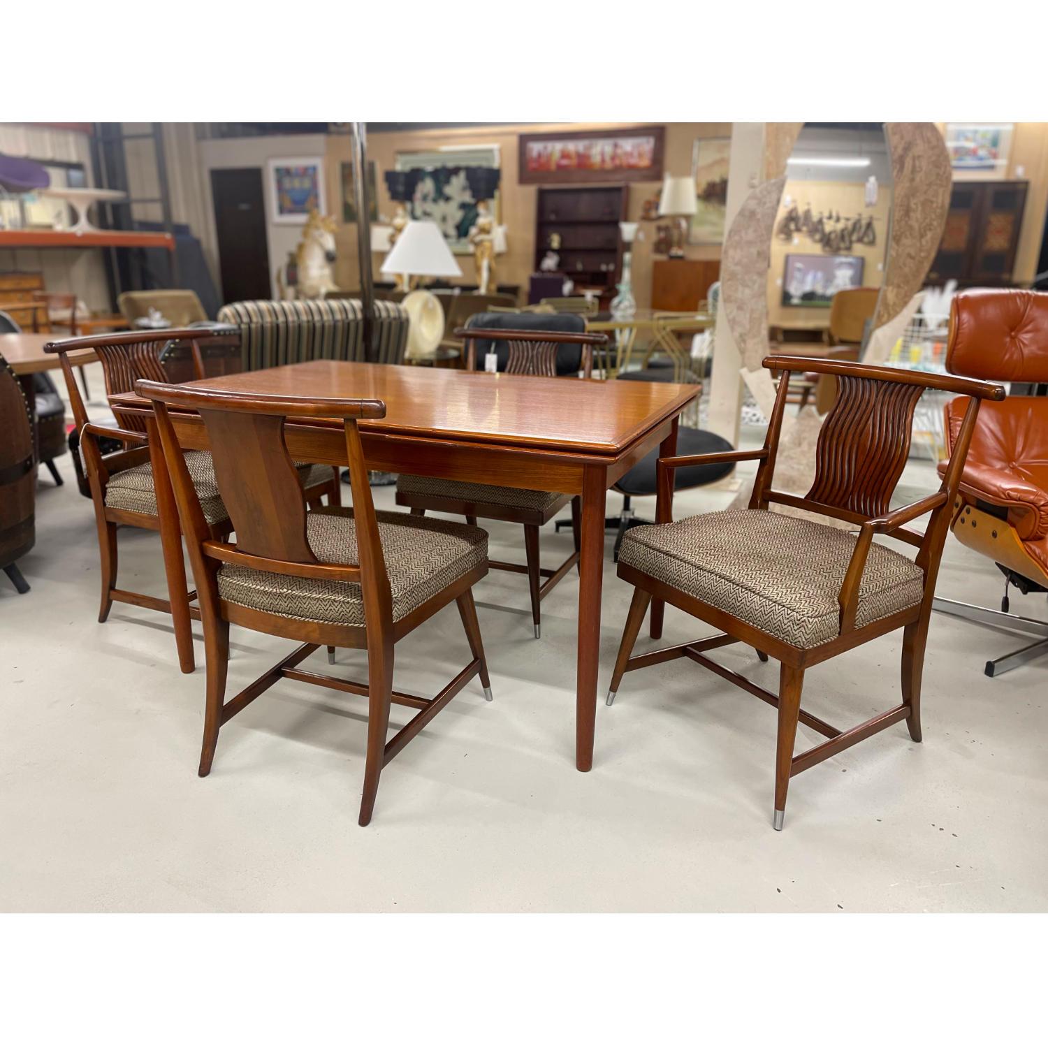 Set of four Mid-Century Modern dining chairs with Asian styling. The set of four includes two arm chairs and two armless side chairs. These chairs are an interesting marriage of modern, traditional and Chinoiserie elements. The vintage chairs have