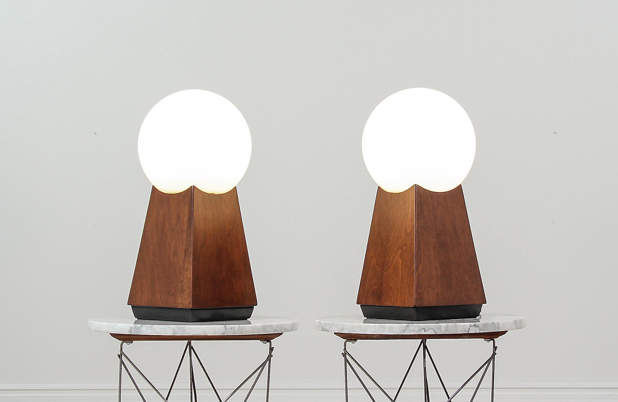 Pair of elegant table lamps designed and manufactured in the United States circa 1960s. These fantastic modern lamps feature a walnut wood body with an exquisite grain detail throughout adding texture and warmth to this rare design. The bases have