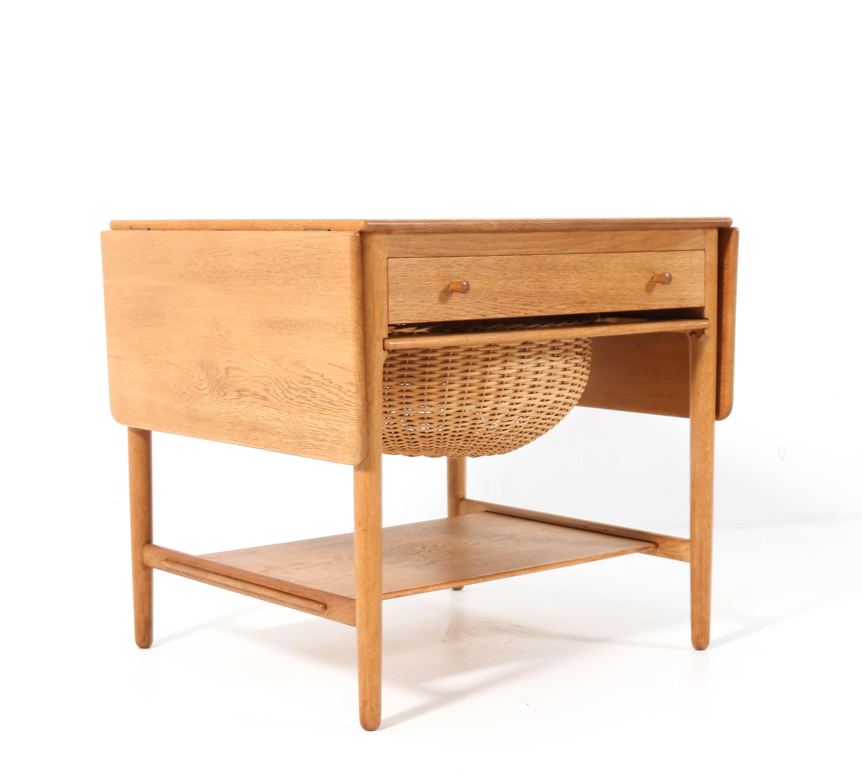 Stunning Mid-Century Modern AT-33 sewing table.
Design by Hans J. Wegner for Andreas Tuck Møbelfabrik.
Striking Danish design from the 1950s.
This version is in solid oak and has two drop-leaves, a front drawer
with several compartments and a