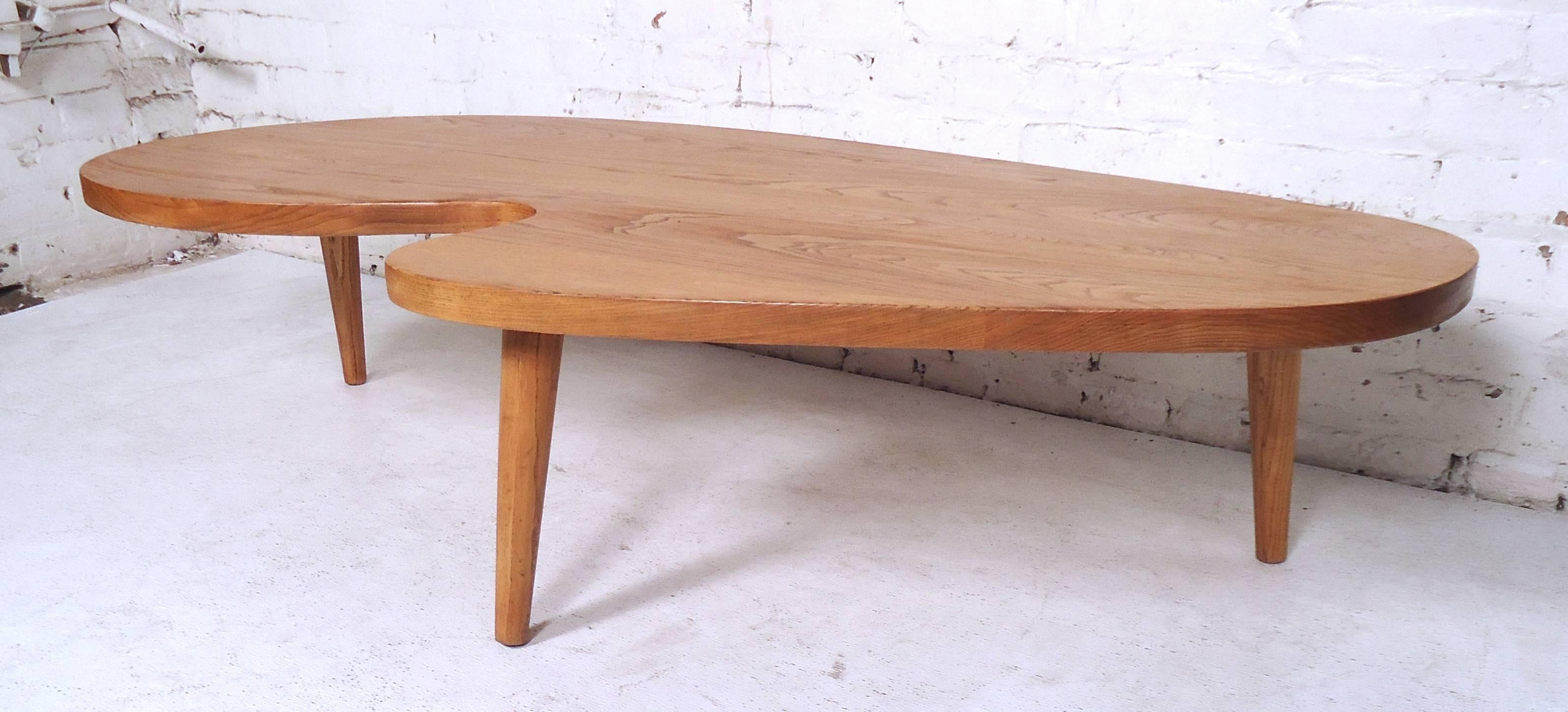 Elegant Mid-Century Modern kidney shape coffee table featuring oakwood grain and tapered legs.

(Please confirm item location - NY or NJ - with dealer).