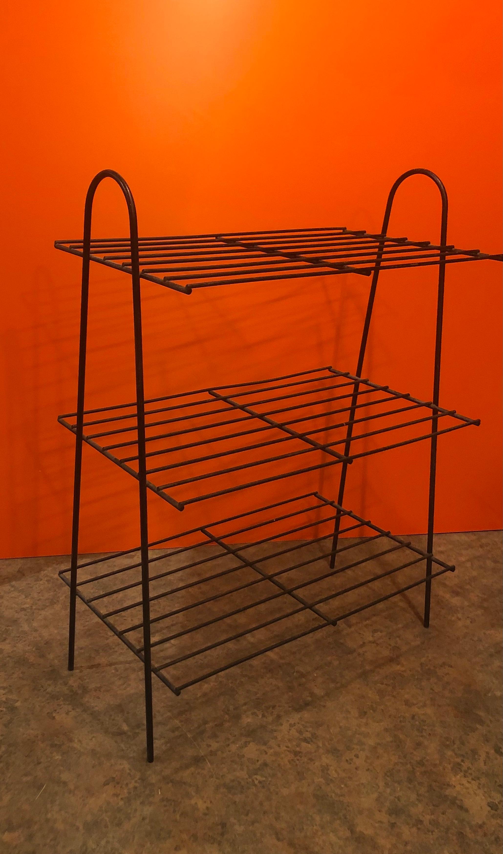 Simple Mid-Century Modern atomic iron wire book shelf or rack, circa 1970s. 

The piece has three shelves and is made of black iron wire and is in good vintage condition with some wear and a great patina. Measurements: 27.5