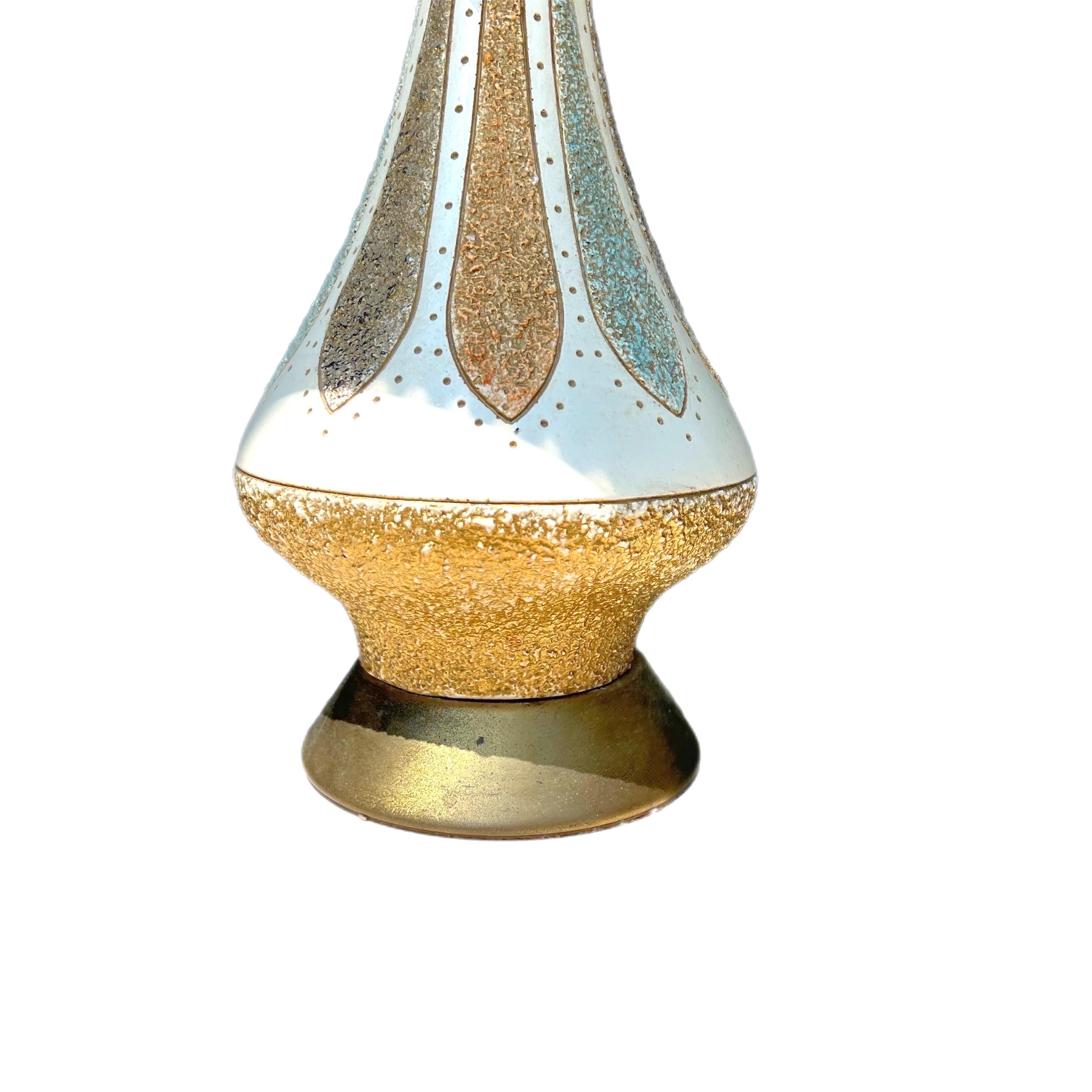 A fabulous colorful Quartzite lamp with a textured body, on a brass base.   The lamp and shade are cream colored and the shade is still in the plastic with no flaws as far as I can tell.  The lamp itself is decorated with turquoise, orange, black,