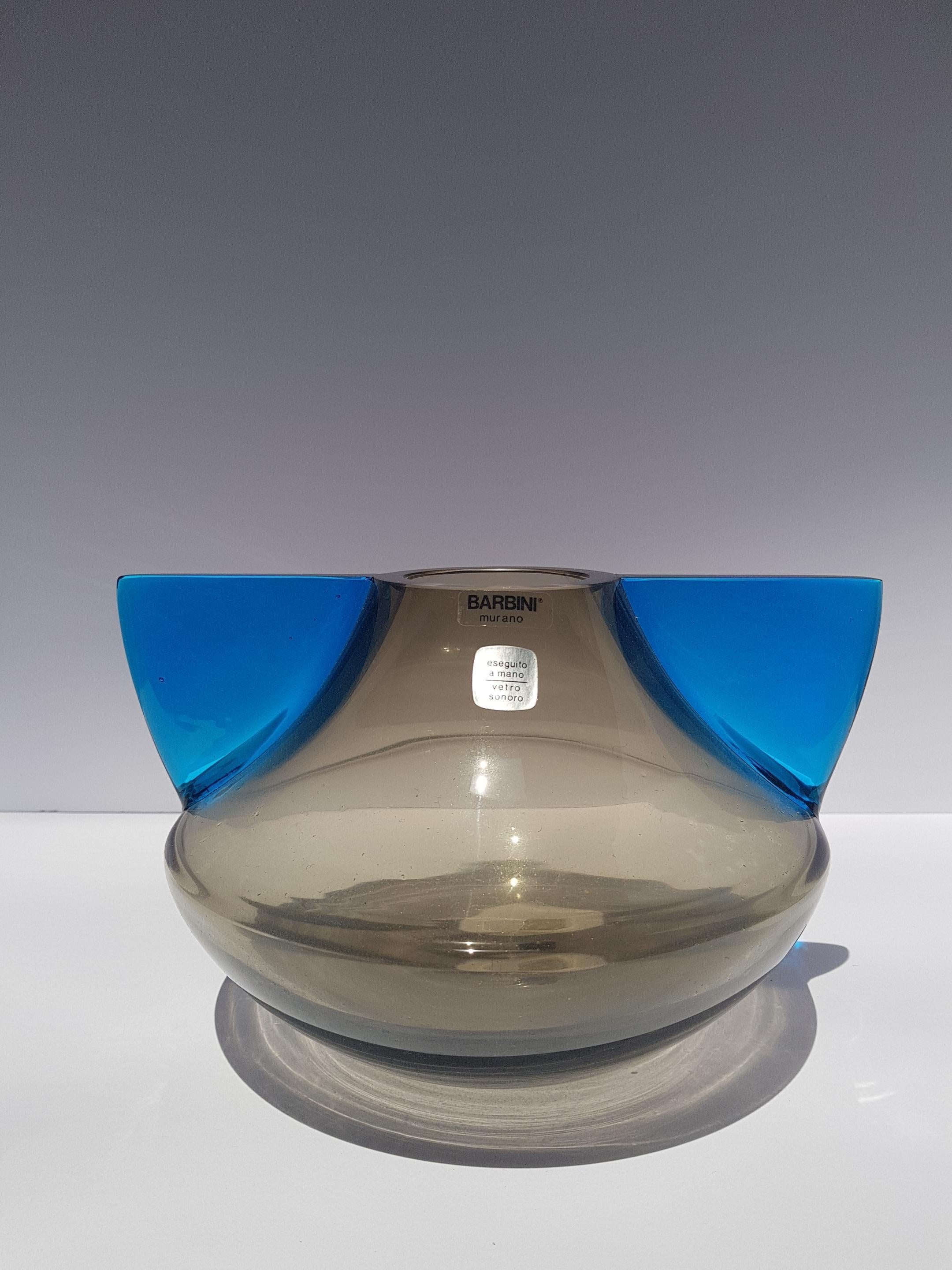 Fantastico e futuristico vaso in vetro artistico dell'era atomica della metà del secolo scorso, realizzato a mano sull'isola veneziana di Murano da Barbini. Forma dinamica con corpo di colore grigio fumo e ali applicate di un blu vibrante e