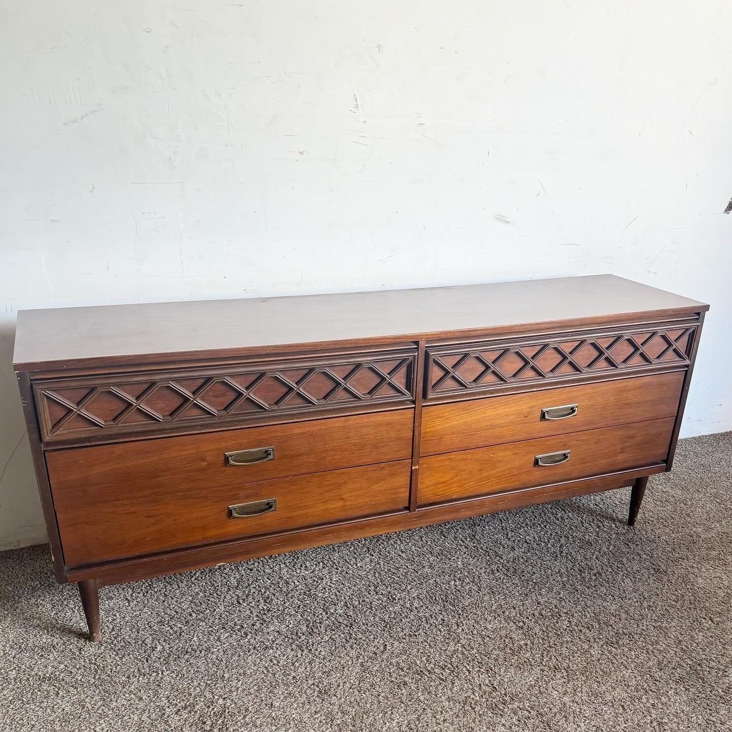 Discover the elegance and simplicity of Mid Century Modern design with this “Tavern Walnut” Dresser by Bassett. Crafted from rich walnut, this dresser embodies the clean lines and functional aesthetics characteristic of the era. It offers ample