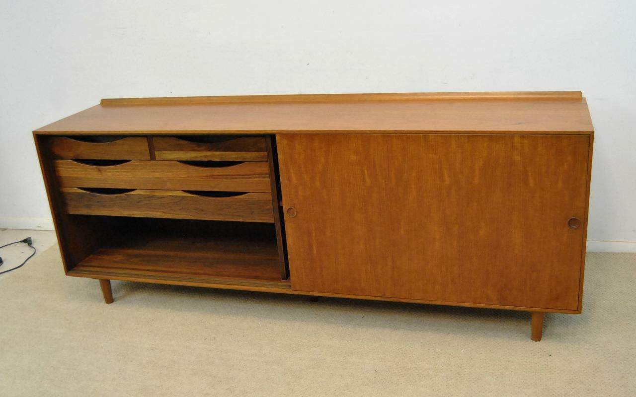 Danish designer Finn Juhl teak Mid-Century Modern credenza for Baker Furniture. Two sliding doors conceal two silver drawers and two linen drawers on one side and single shelf interior compartment on the other. Very nice condition. Measures: 78