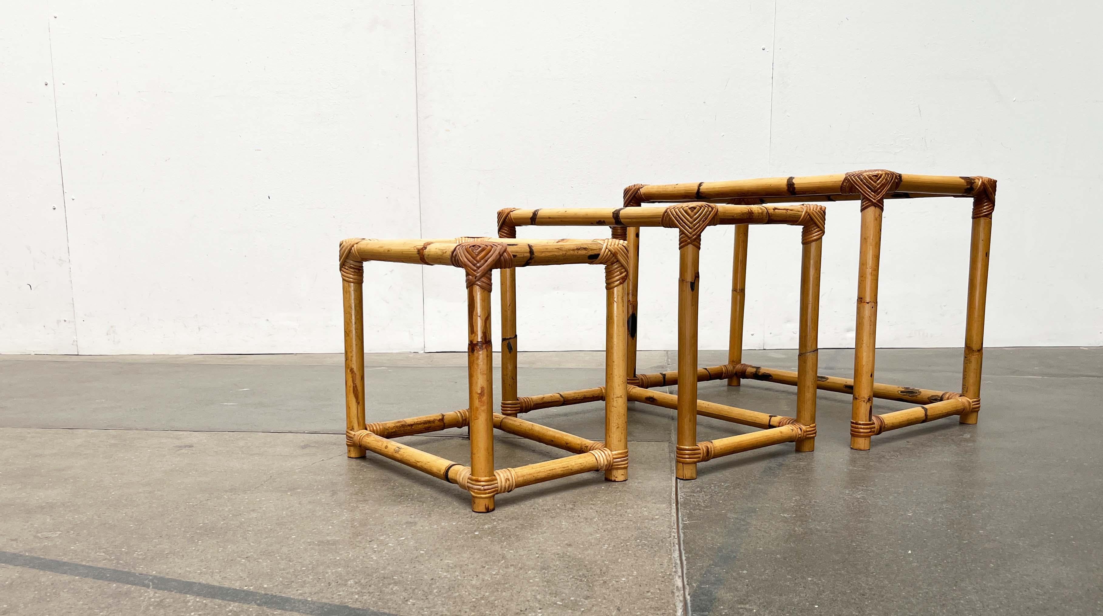 Mid Century nesting tables with bamboo frame and glass top.

This set of 3 nesting tables can be pushed into each other to save space. The frames are made of bamboo. The corners and connections are decoratively decorated with straps. Inlaid smoked