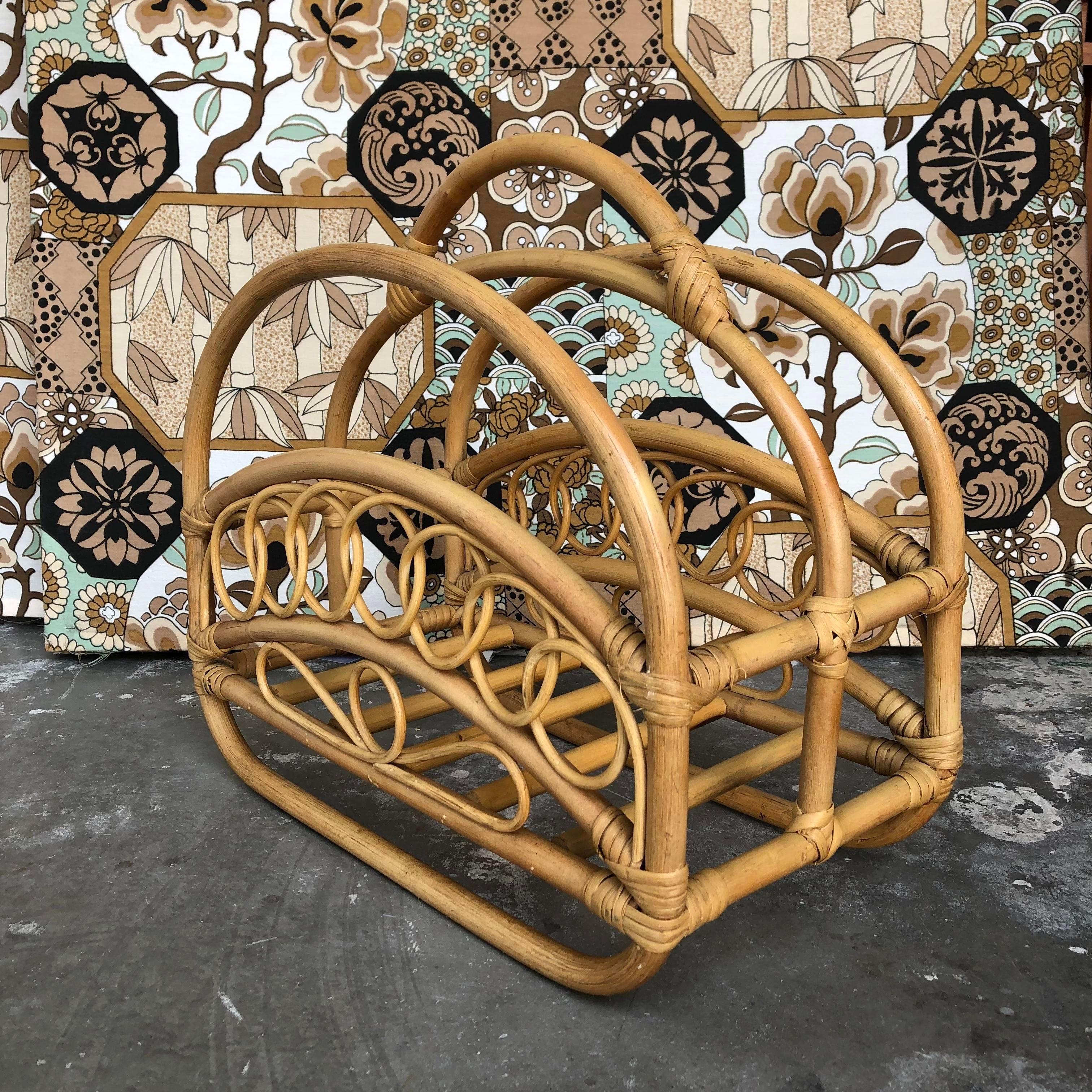 Vintage Mid Century Modern Bamboo and Rattan Magazine Rack in The Franco Albini Style. C 1970s
Features a natural color bent bamboo frame with a curved handle and undulating trellis pattern design on both sides.
In Very Good Original Condition with