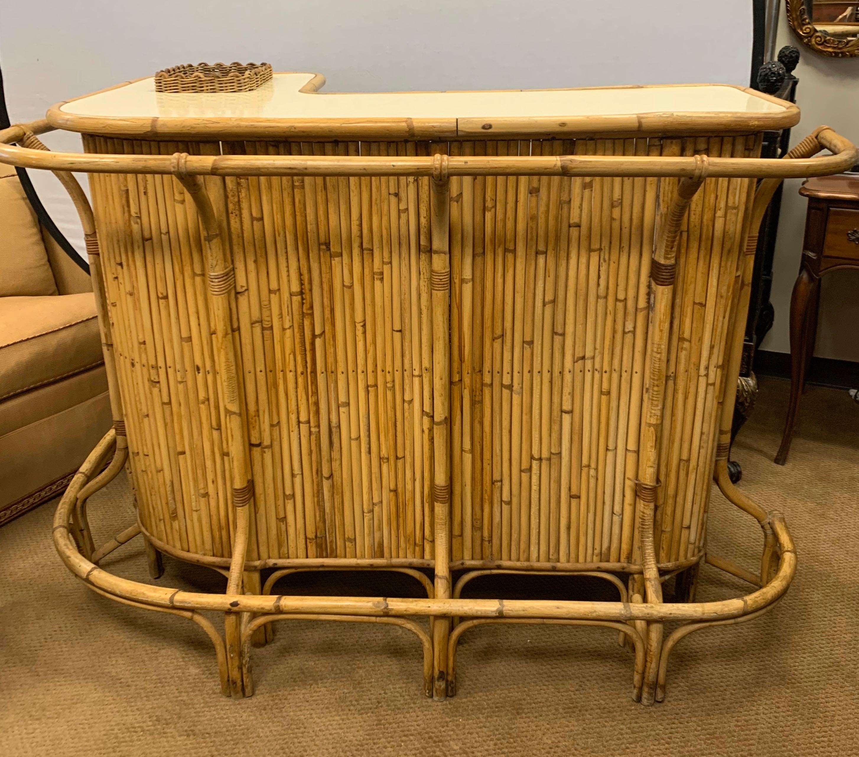 Mid-Century Modern 1970s bamboo bar with formica top. Features plenty of storage, a drop in ice area and a great railing that goes all around. It has been preserved by original Palm Springs, CA owner. All dimensions are below for the bar.