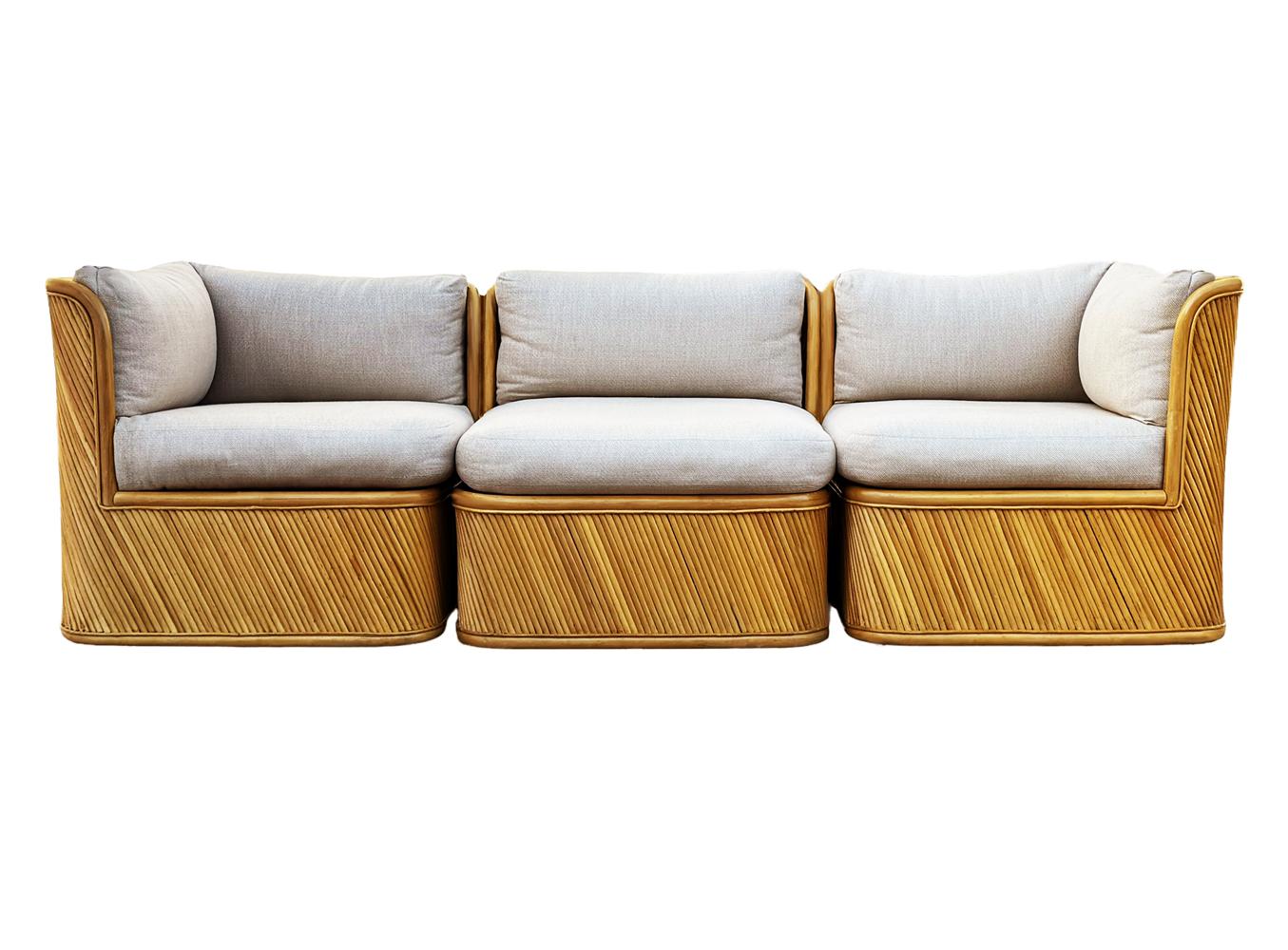 Un canapé élégant et sculptural fabriqué par Comfort Design/One Furniture dans les années 1970. Le canapé se caractérise par une construction lourde, un design sculptural et un revêtement en roseaux de bambou. Les coussins ont été récemment