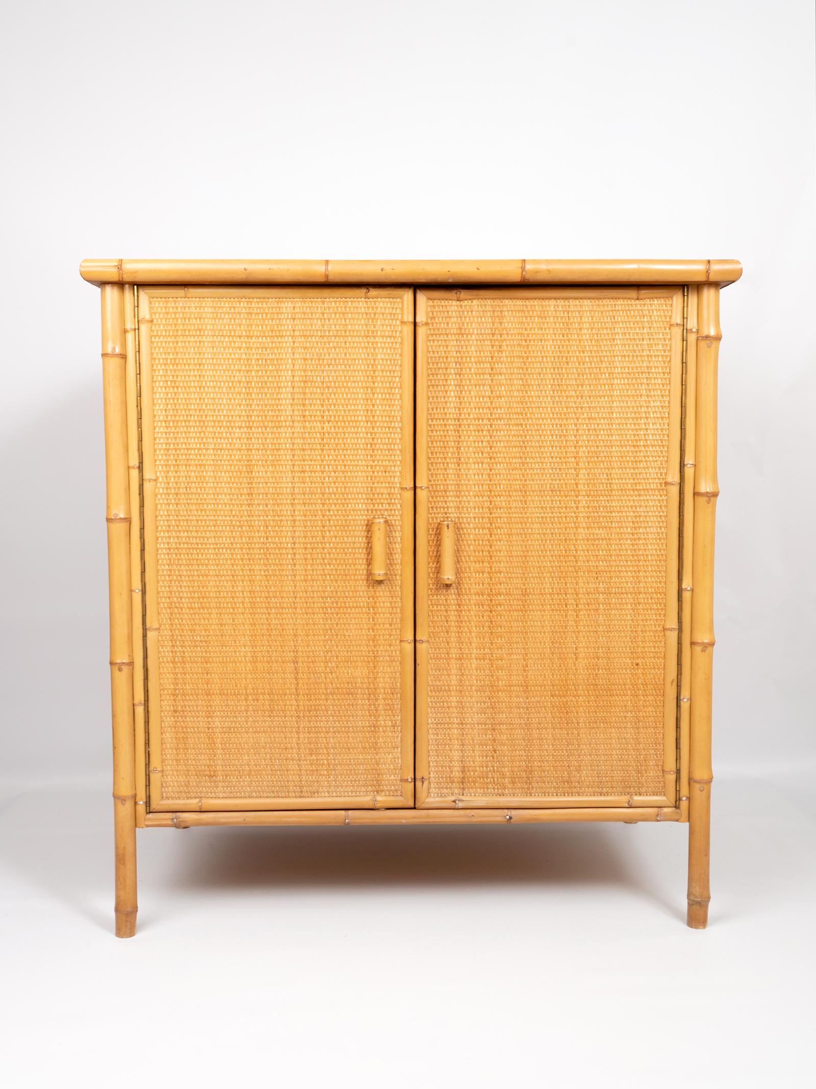 Moderner Schrank aus Bambus und Rattan mit abnehmbarer Original-Rauchglasplatte, Spanien, um 1970.
In sehr gutem, altersentsprechendem Vintage-Zustand.