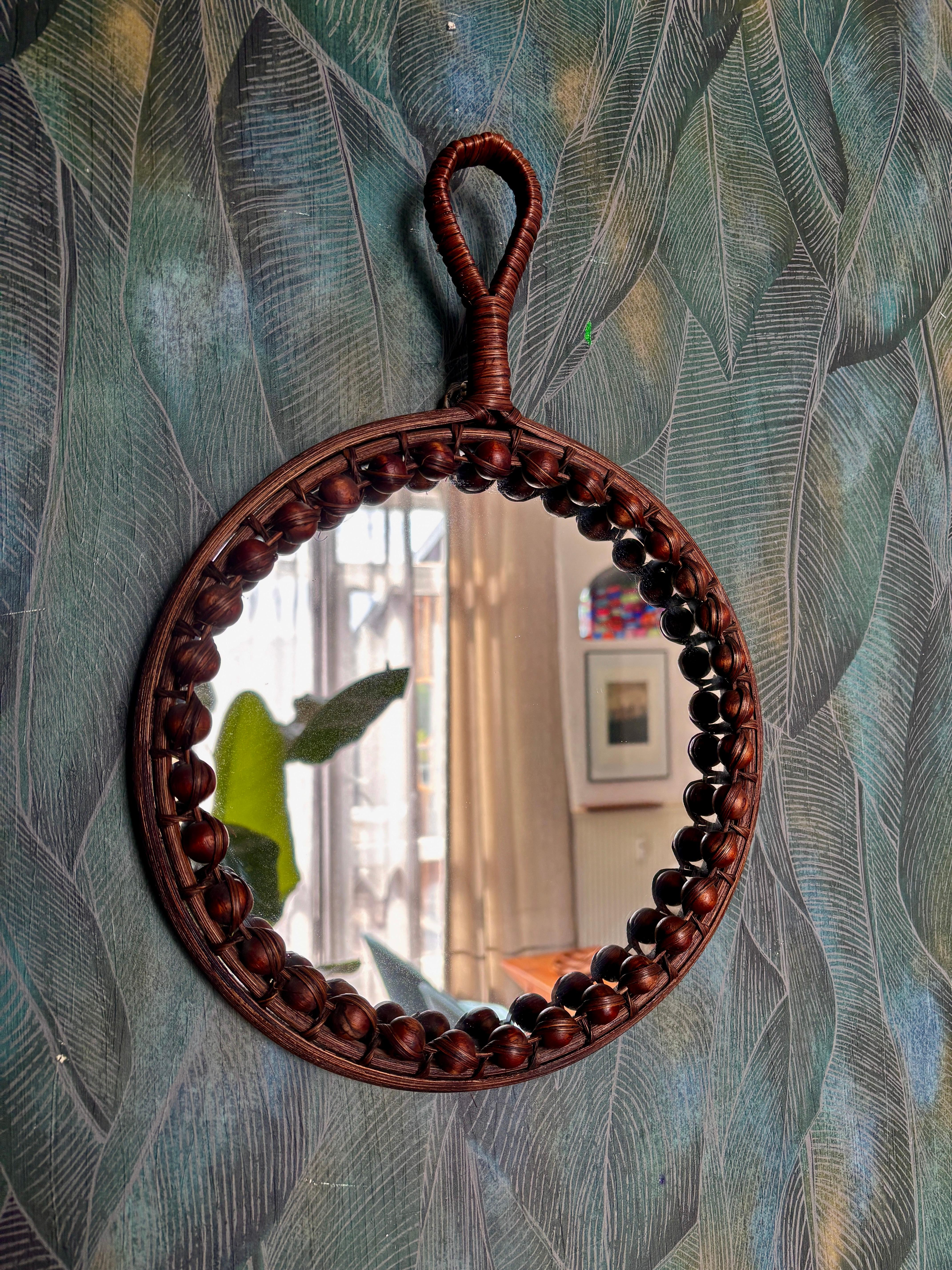 Un delicato specchio da parete in rattan e bambù, realizzato a mano, risalente alla metà del secolo scorso. Di un artigiano sconosciuto, circa 1960. Condizioni originali con lievi segni di usura dovuti all'età e all'uso, che lasciano una bella