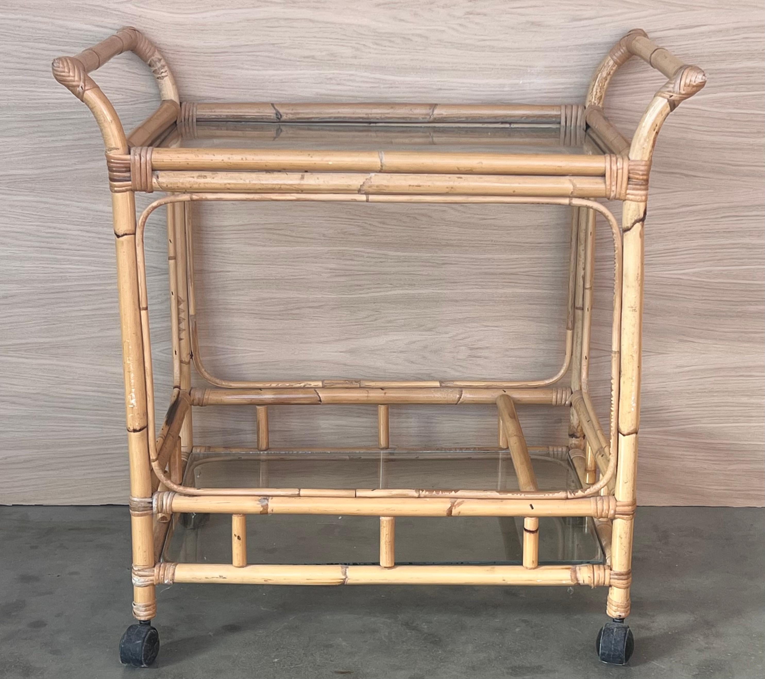 Mid-Century Modern bamboo tea cart, Fabulous from the 1950s. Made in bamboo with four wheels. Bottle rack on the low shelve.
In perfect condition.
Perfect for a collected garden of potted plants, or extra kitchen storage.


Height to the low shelve: