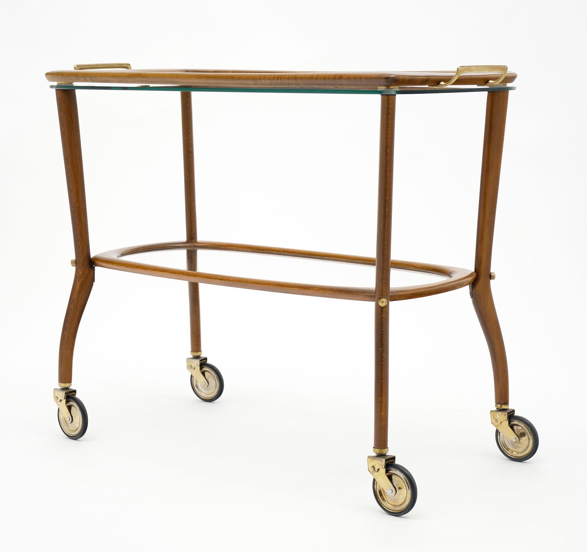 Bar cart from Italy by designer Cesare Lacca. This piece is made of beech wood and glass. There is a top tray that lifts off for functionality.