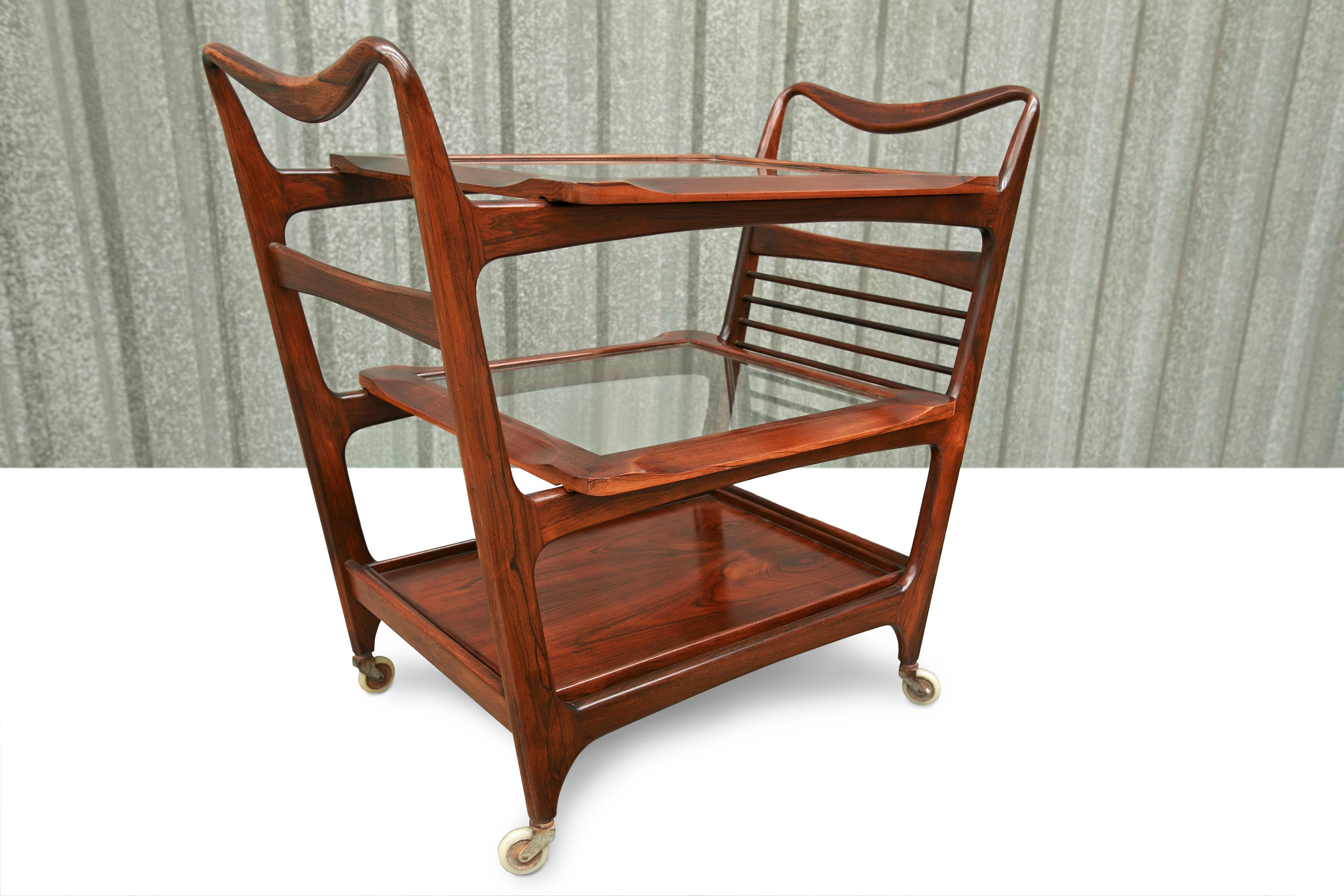 Available right now, this very Mid-Century Modern Bar Cart in Hardwood & Glass by Carlo Hauner & Martin Eisler, designed in Brazil in the sixties is nothing less than spectacular! 

The bar cart features a wood structure in solid rosewood with its