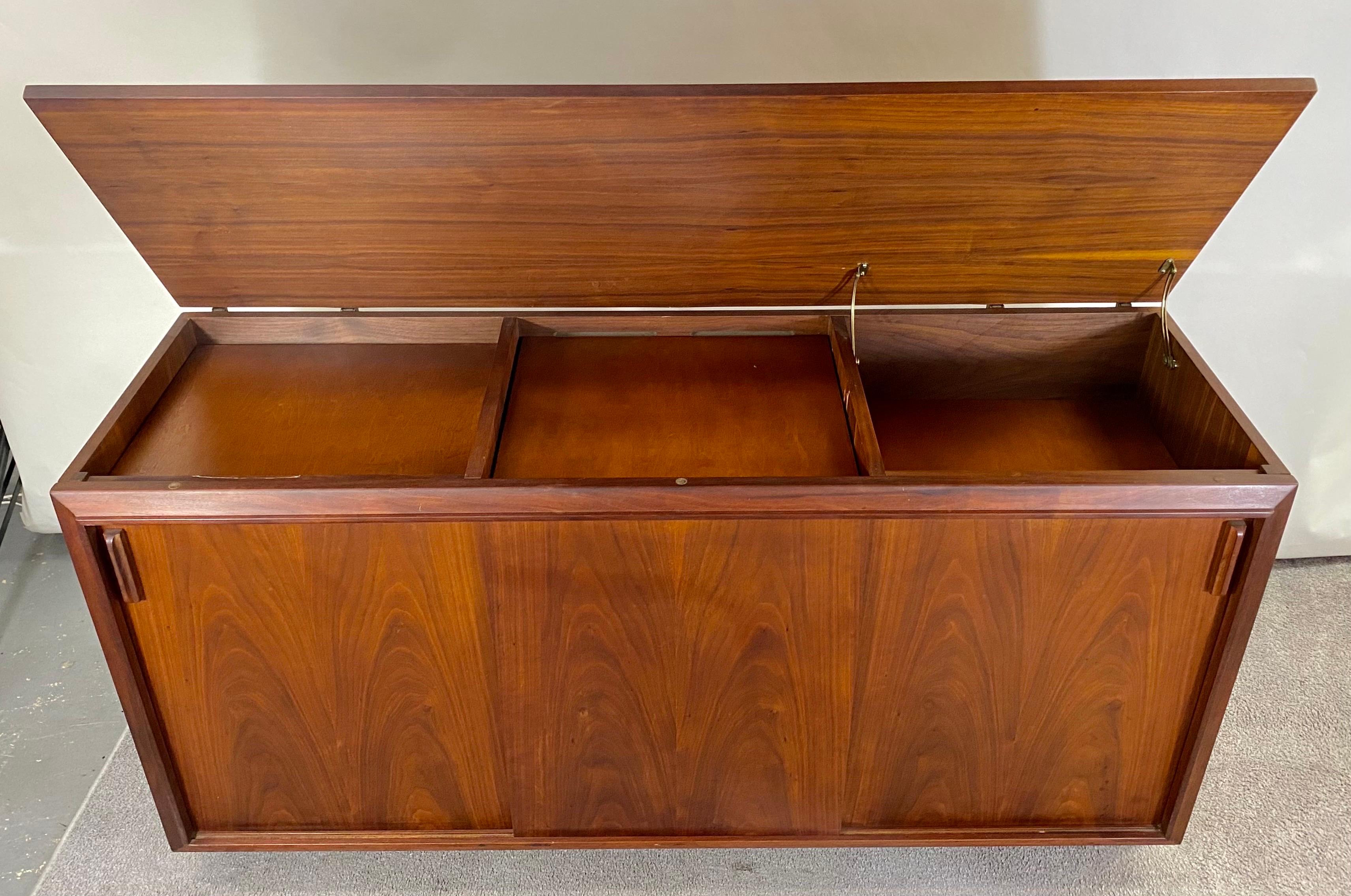 A quality Mid-Century Modern sideboard, credenza by Brazilay. The fine cabinet was originally a stereo console and was converted to sideboard. The Brazilay sideboard features three cabinet spaces for storage space. The top when lifted offers more